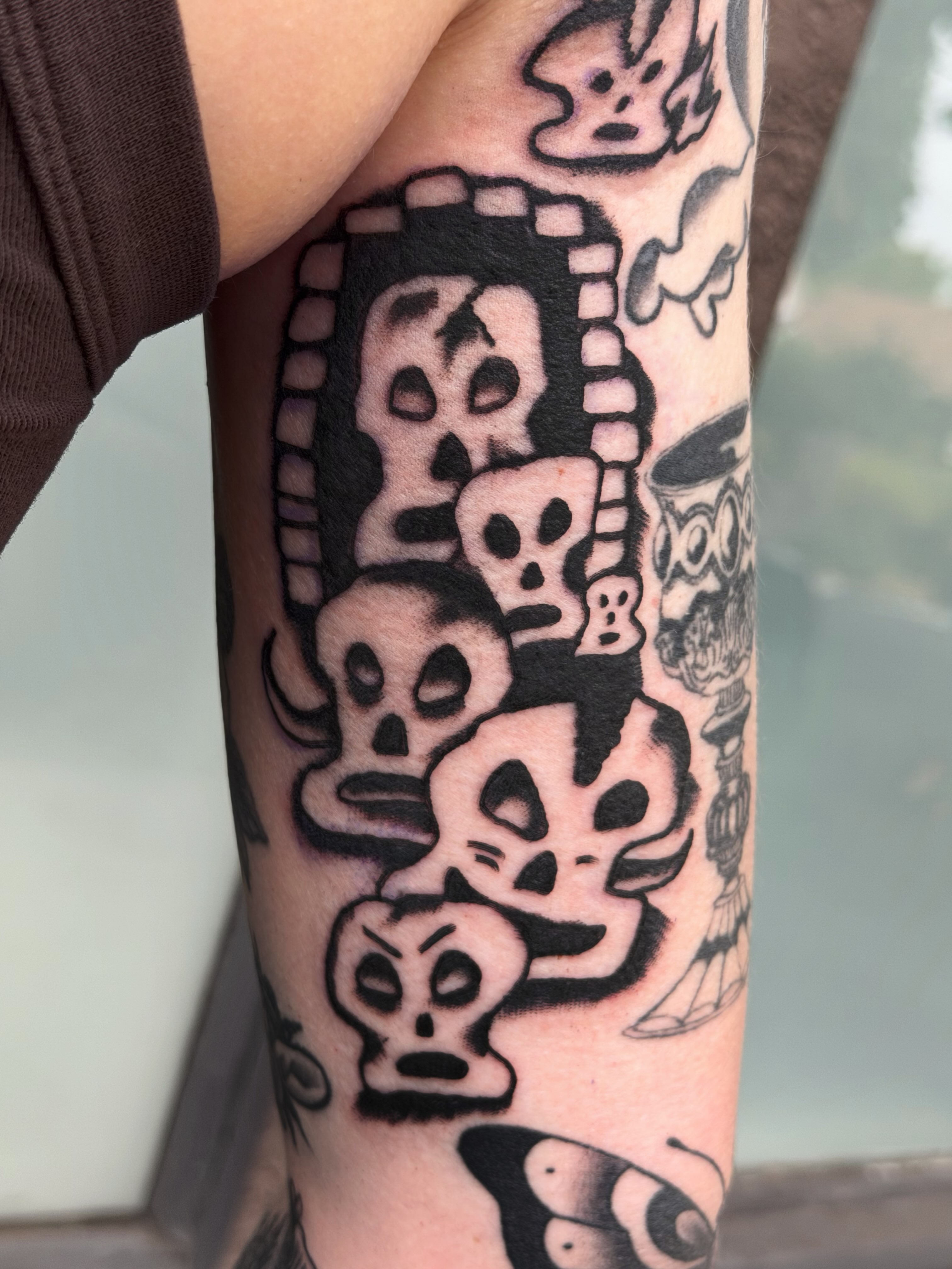 Skulls black and grey tattoo on the forearm by Jake