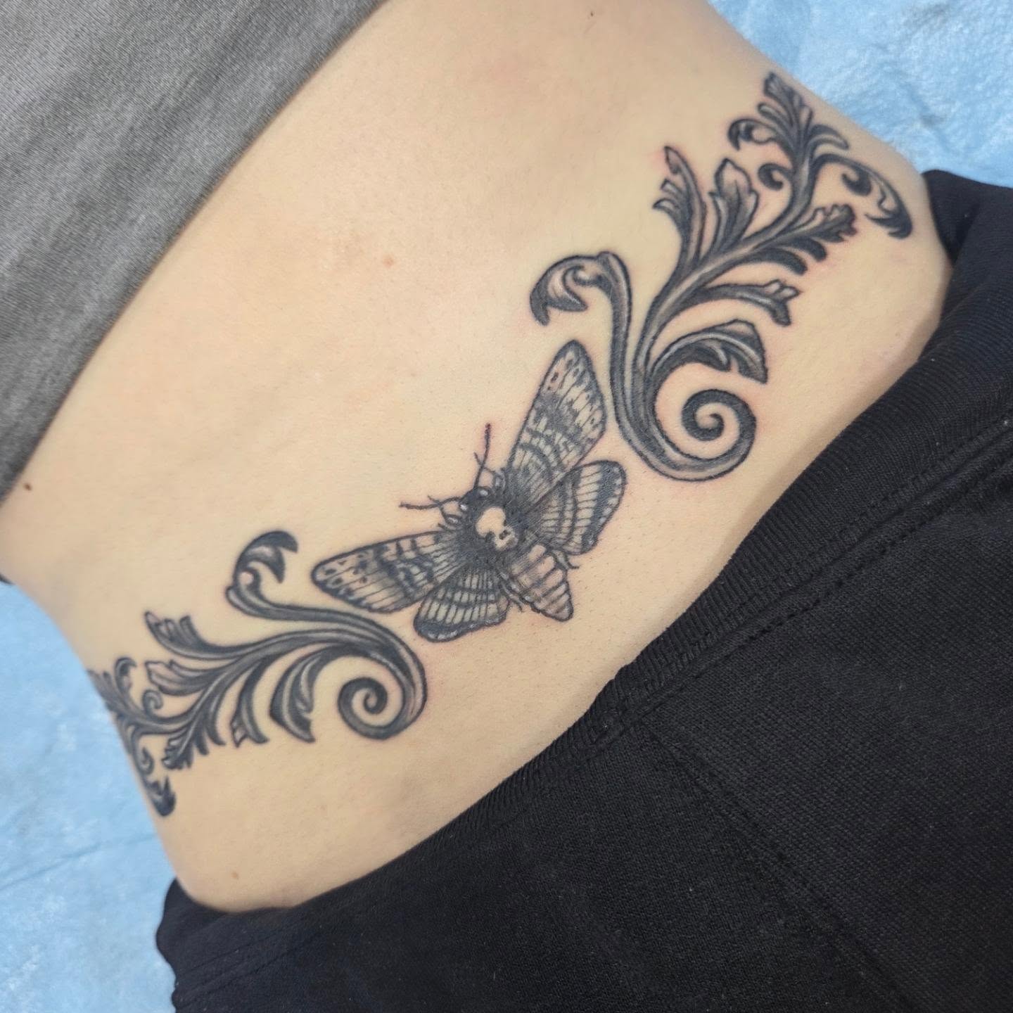 Moth and floral vine black and grey tattoo on the ribs by Matthew Todd Kremer