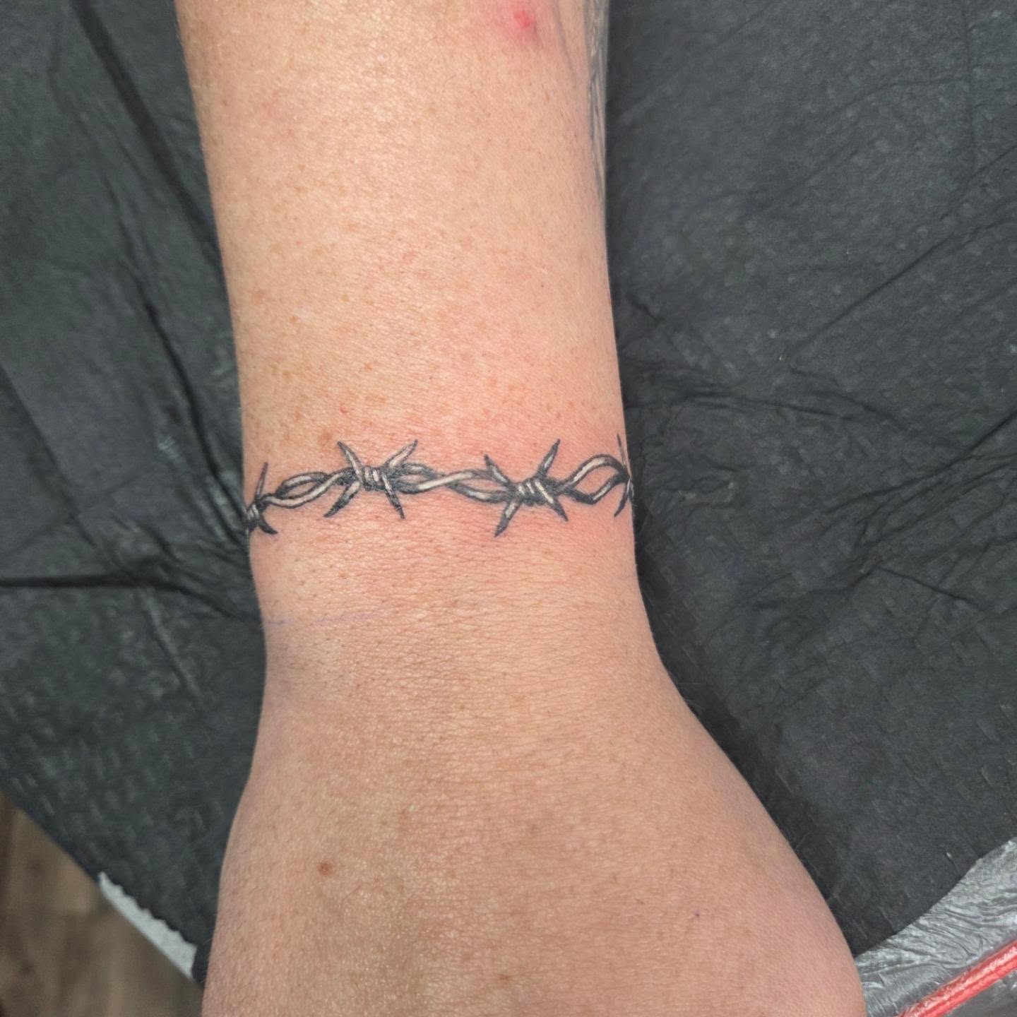 Barbed wire black and grey tattoo on the forearm by Matthew Todd Kremer