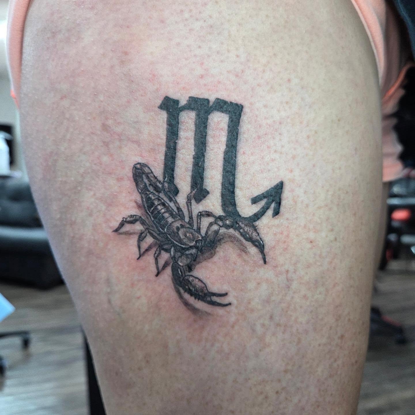 Scorpion and Virgo symbol black and grey tattoo on the thigh by Matthew Todd Kremer