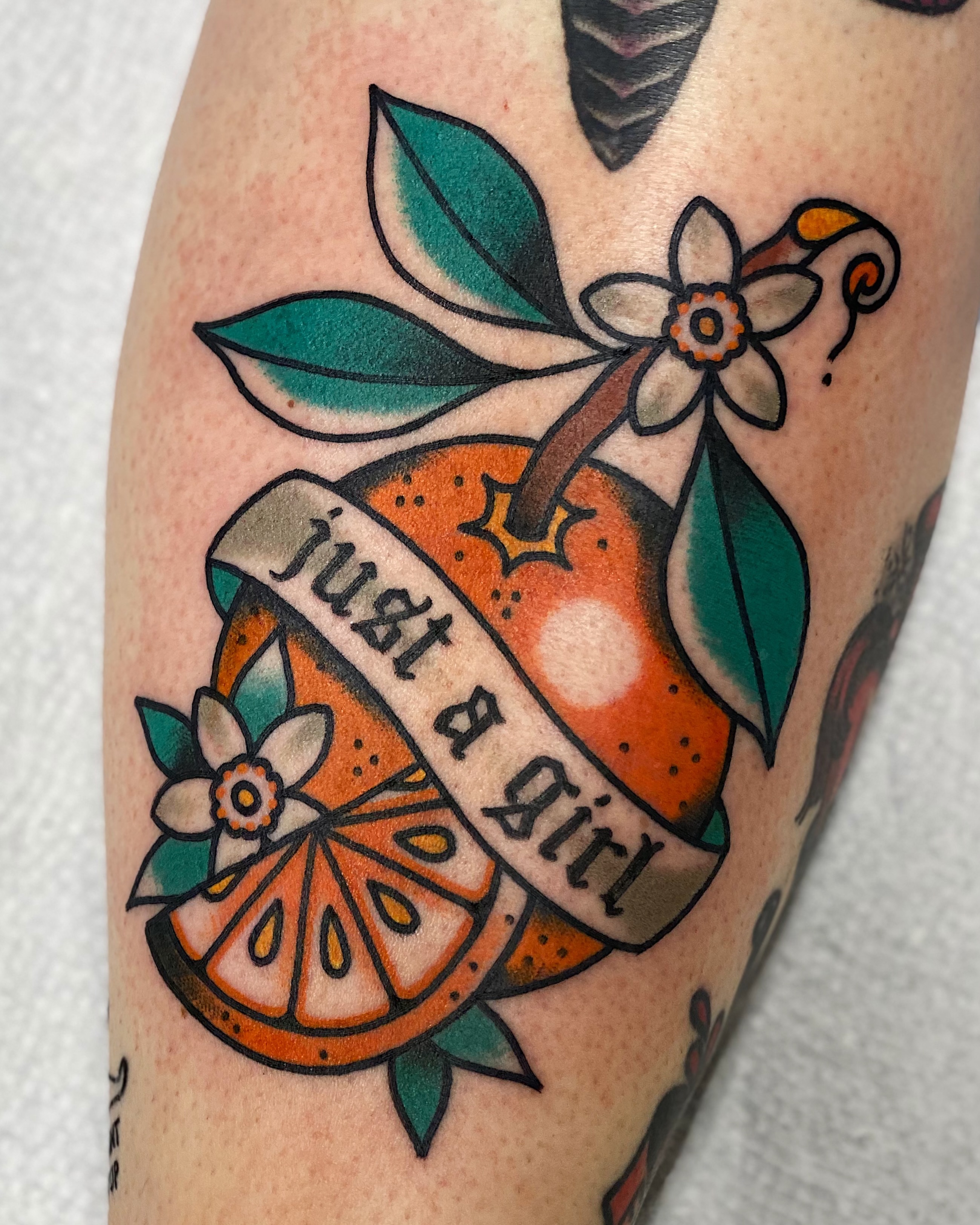 Orange slice American traditional tattoo on the forearm by Dakota Amato
