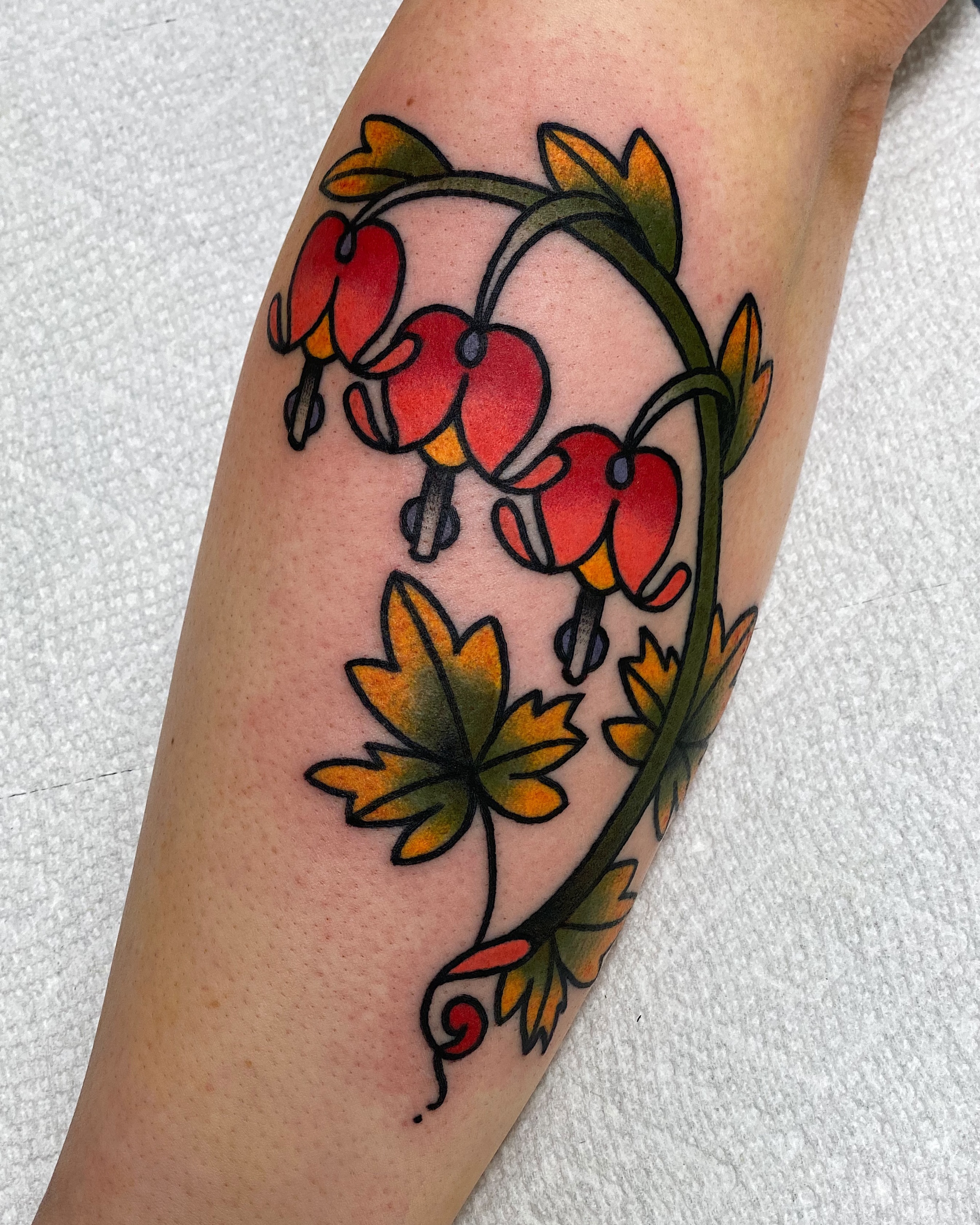 Bleeding heart flowers American traditional tattoo on the forearm by Dakota Amato