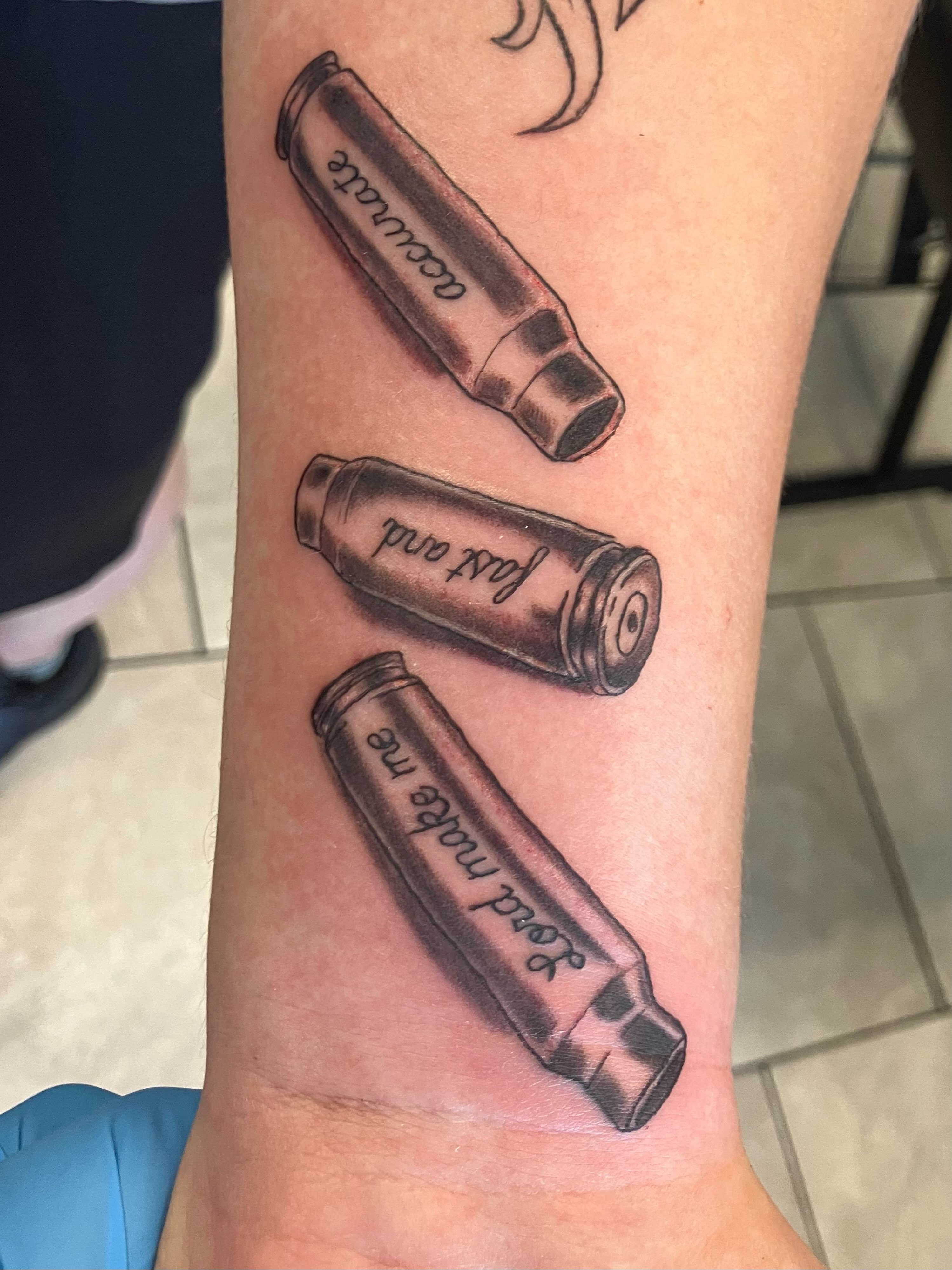 Bullet casings black and grey tattoo on the forearm by Bryant Johnson