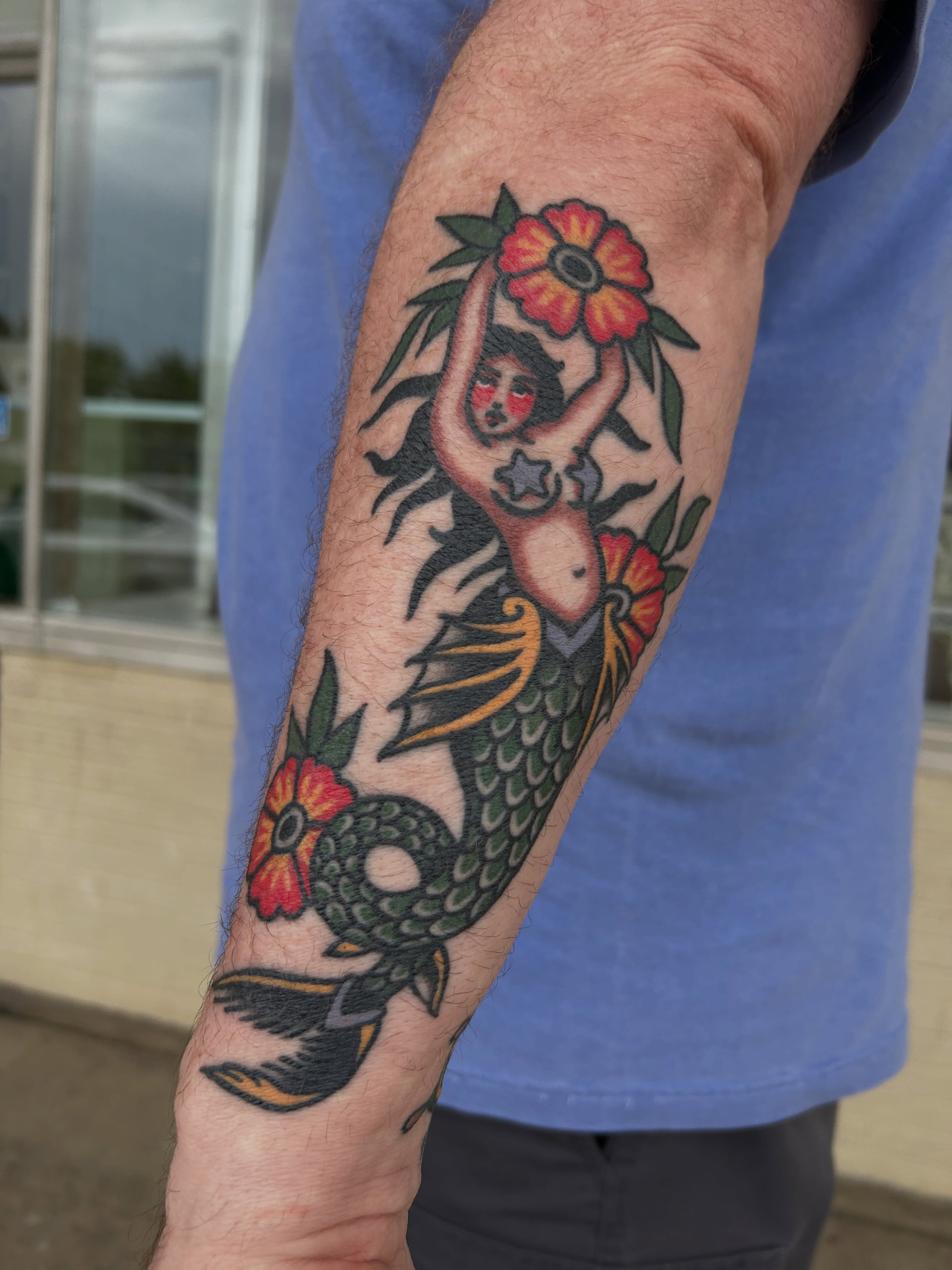 Mermaid with flowers American traditional tattoo on the forearm by Mitch Hoggard