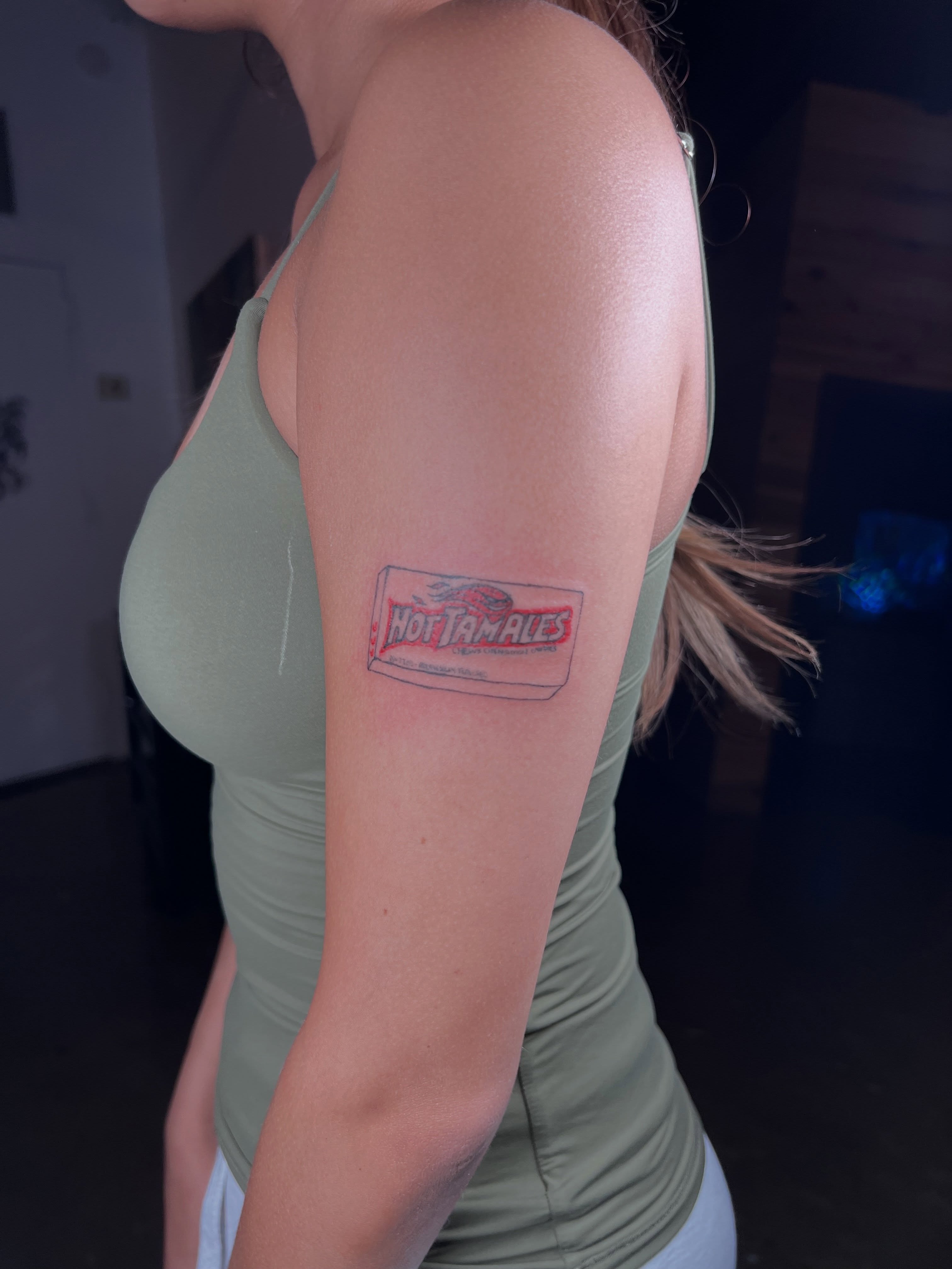 Hot Tamales candy box lettering script tattoo on the upper arm by ★𝐑𝐮𝐞★