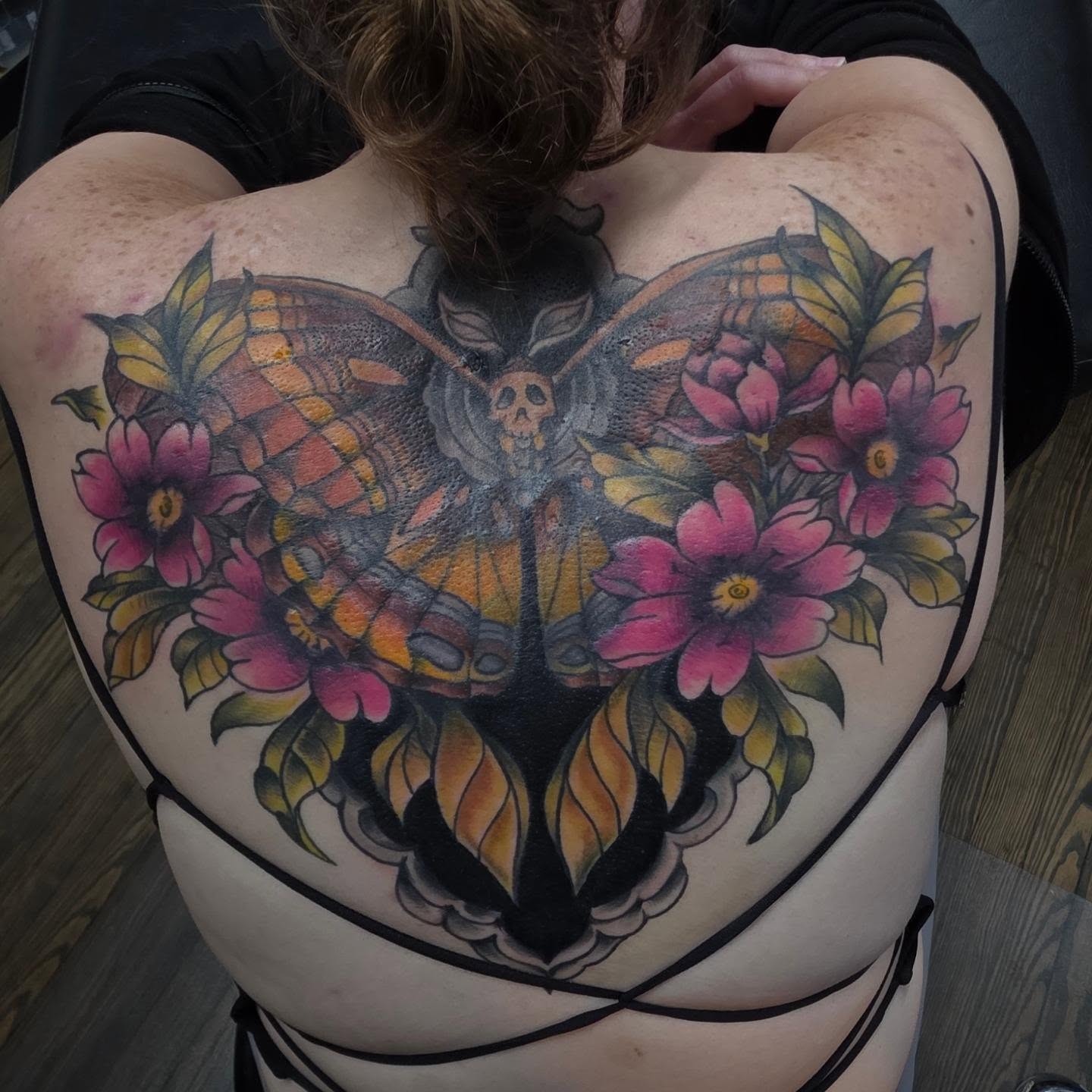 Butterfly and flowers American traditional tattoo on the back by Moe