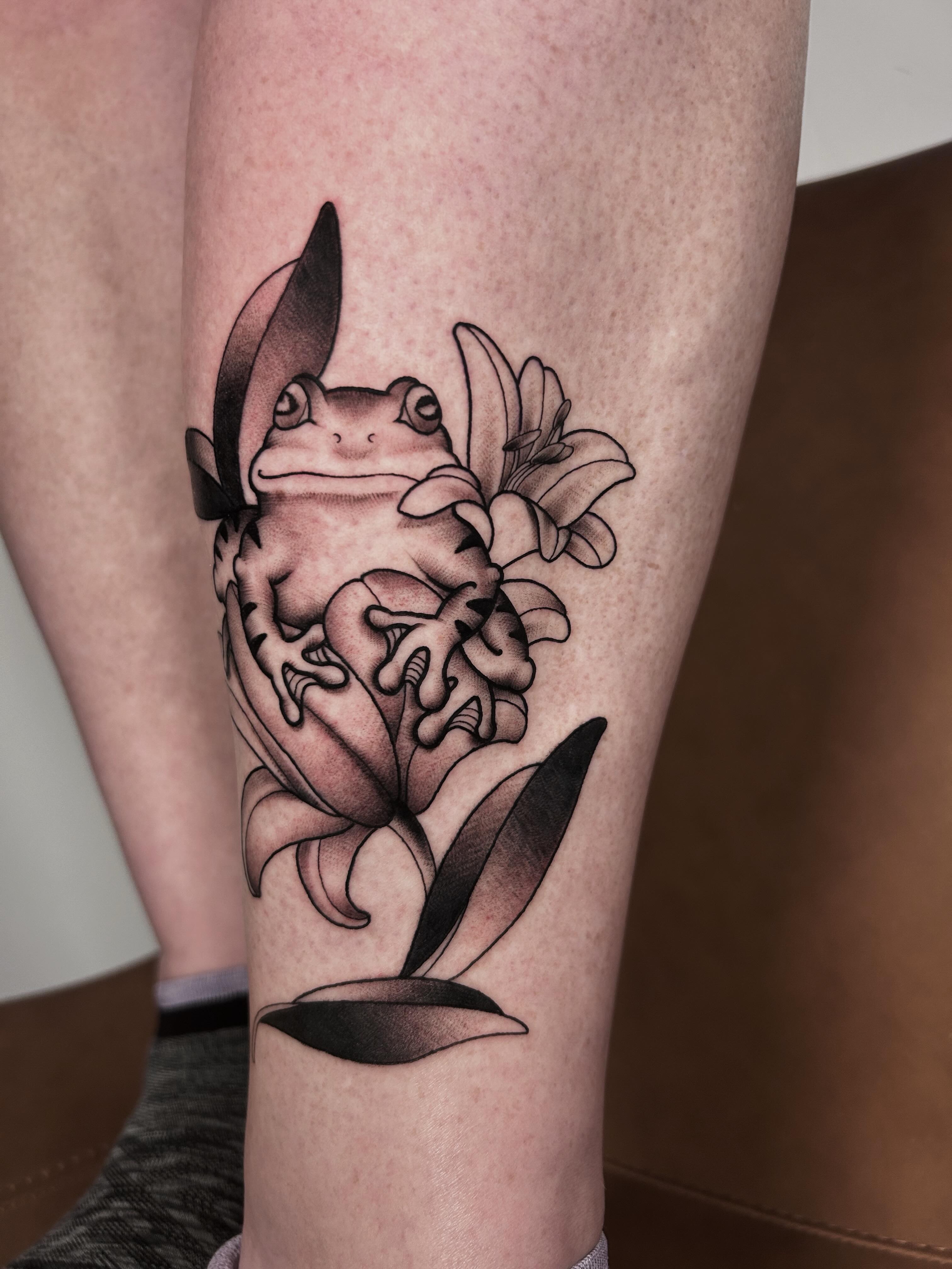 Frog and lily black and grey tattoo on the forearm by Salt Lake City tattoo artist