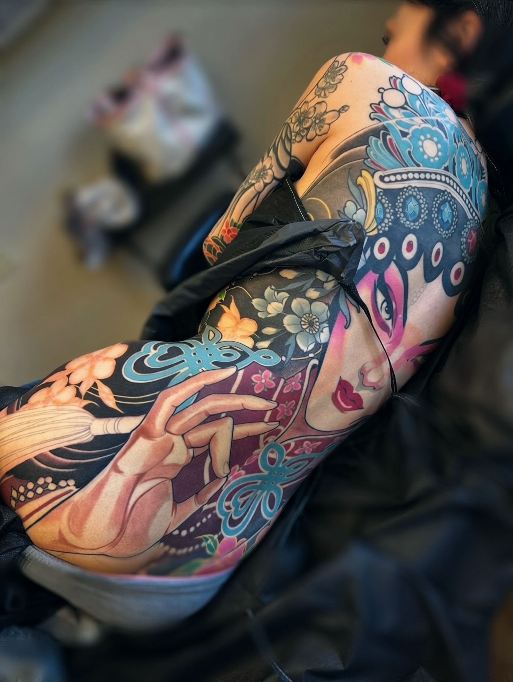 Woman with broomstick new school tattoo on the upper arm by Jeff Norton, Atascadero, California
