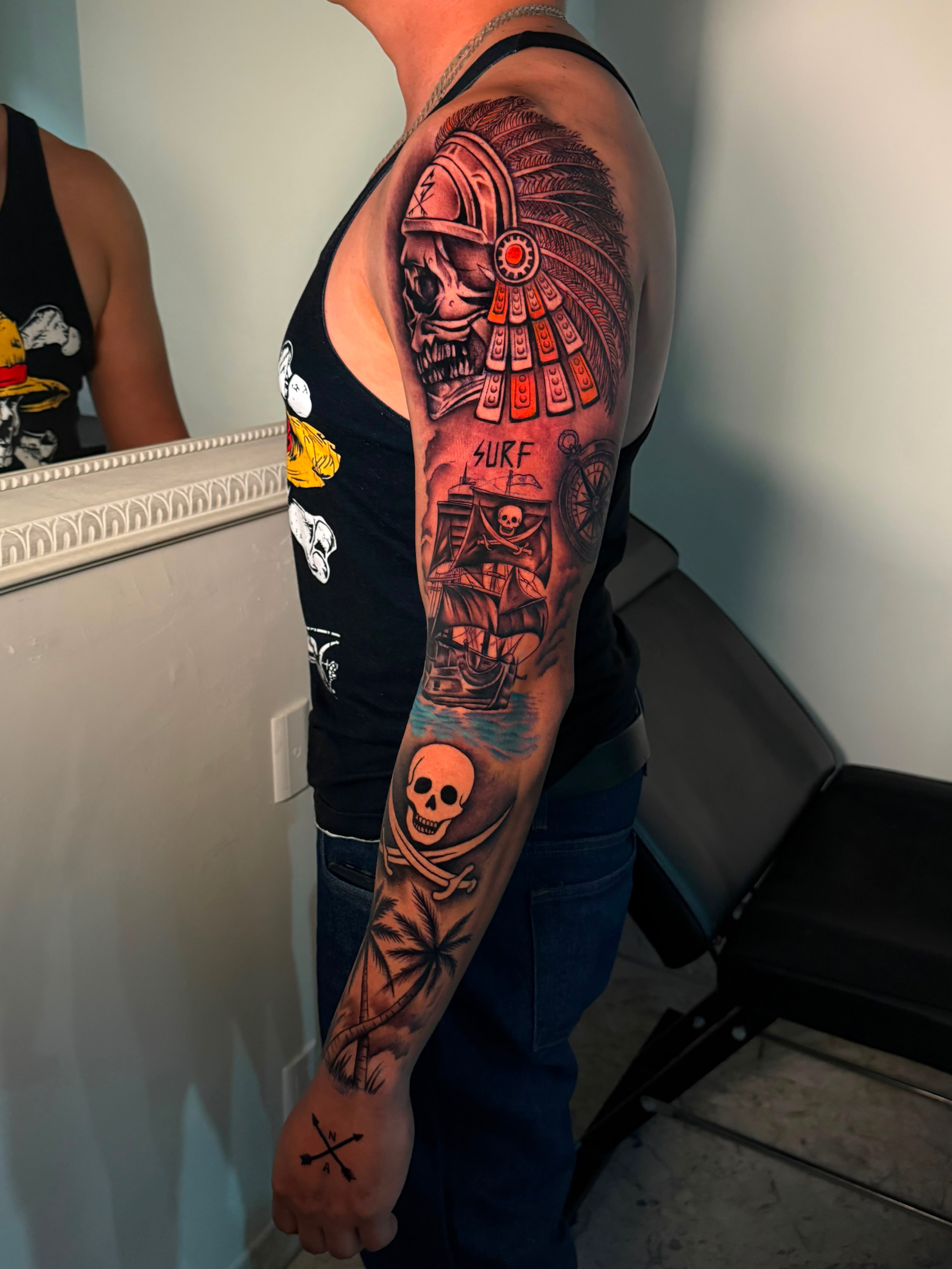 Pirate ship and skull realism tattoo on the upper arm by Tattoo Artist