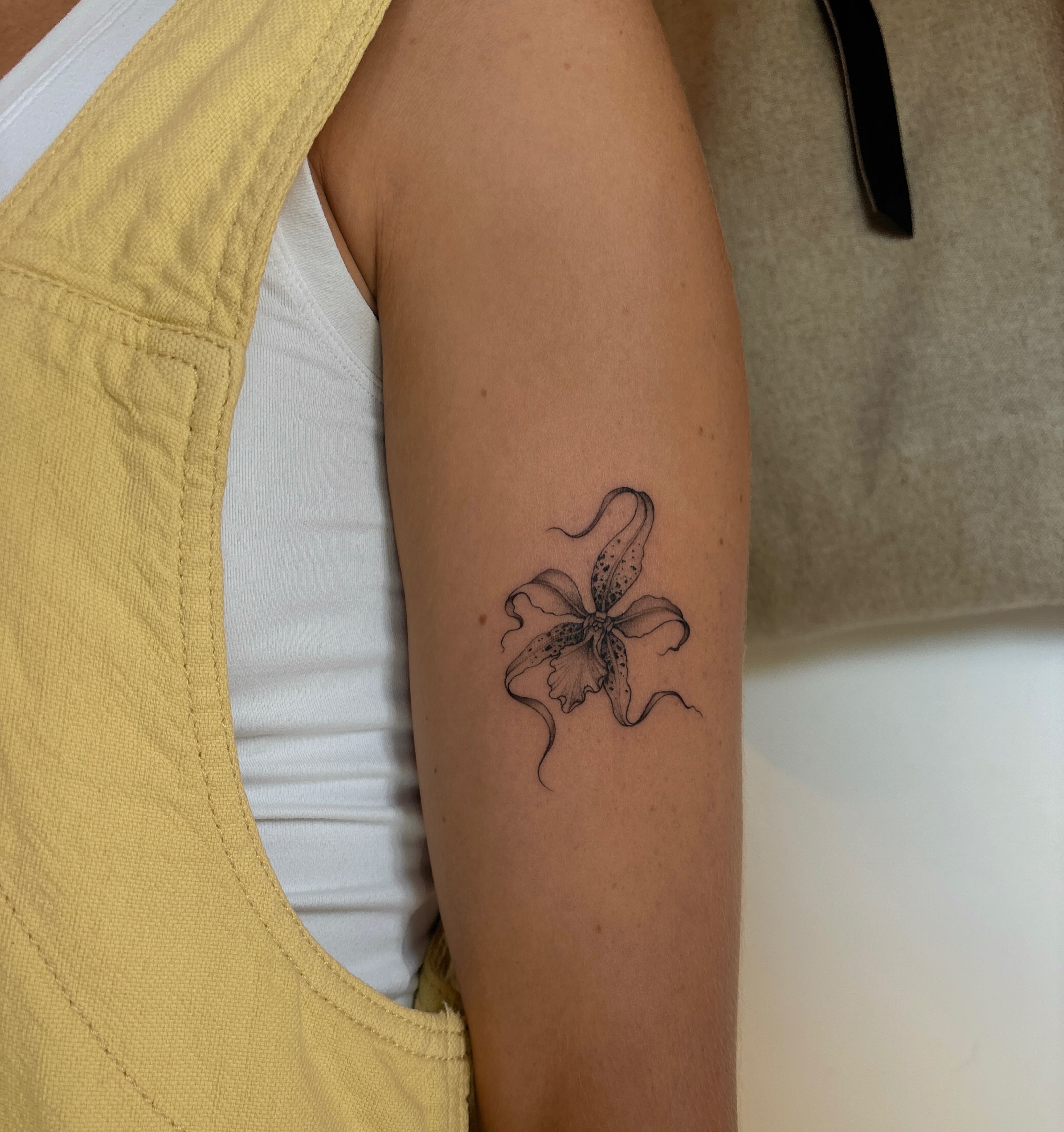 Orchid black and grey tattoo on the forearm by Emma Cotter