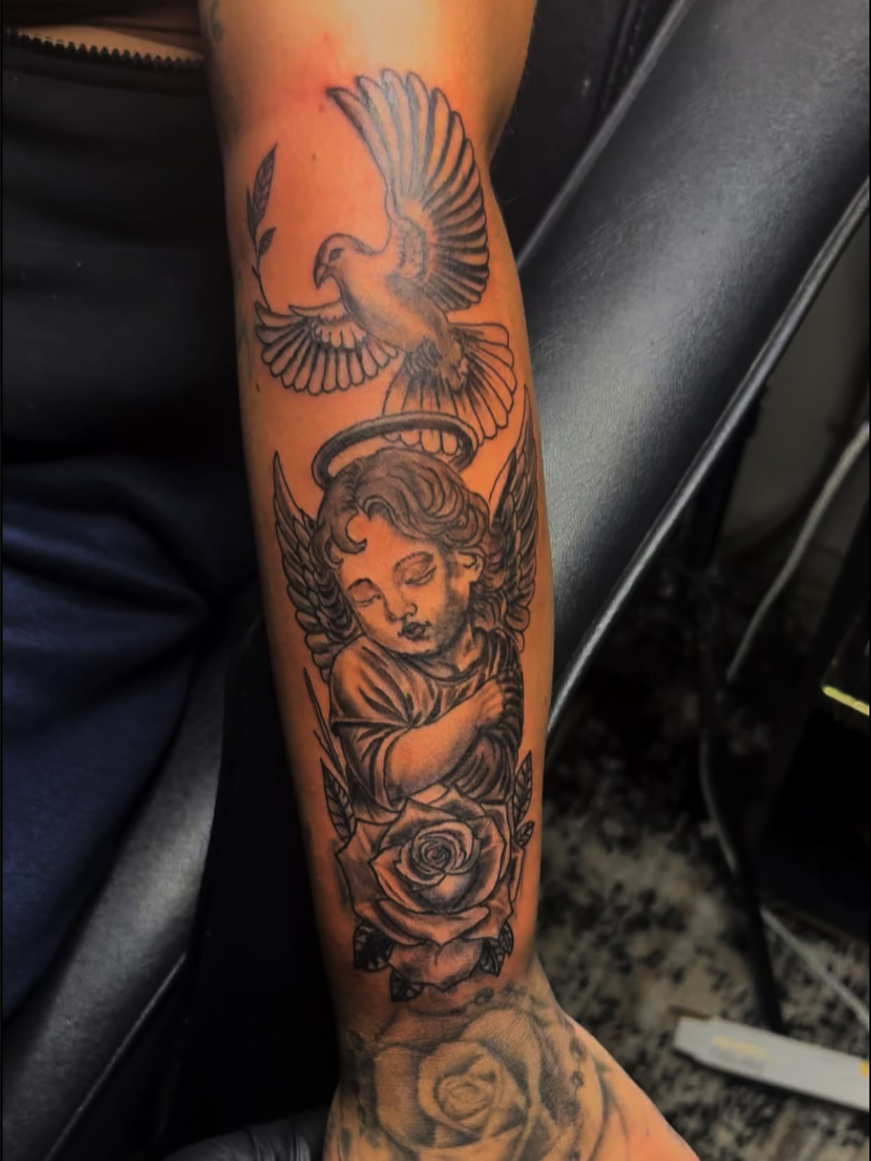 Angel with dove black and grey tattoo on the forearm by sams tattoos