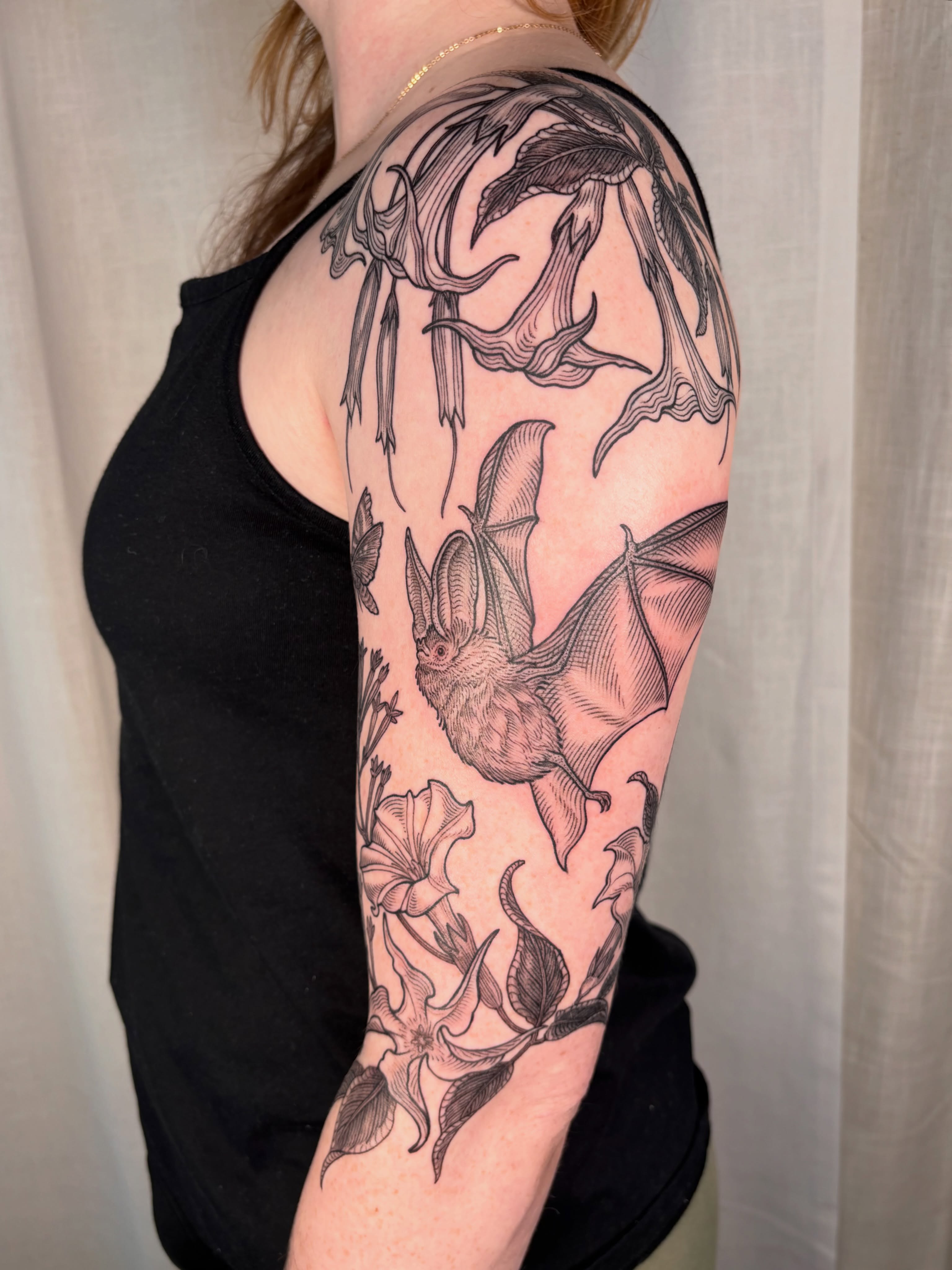 Bat and flowers realism tattoo on the forearm by Maggie
