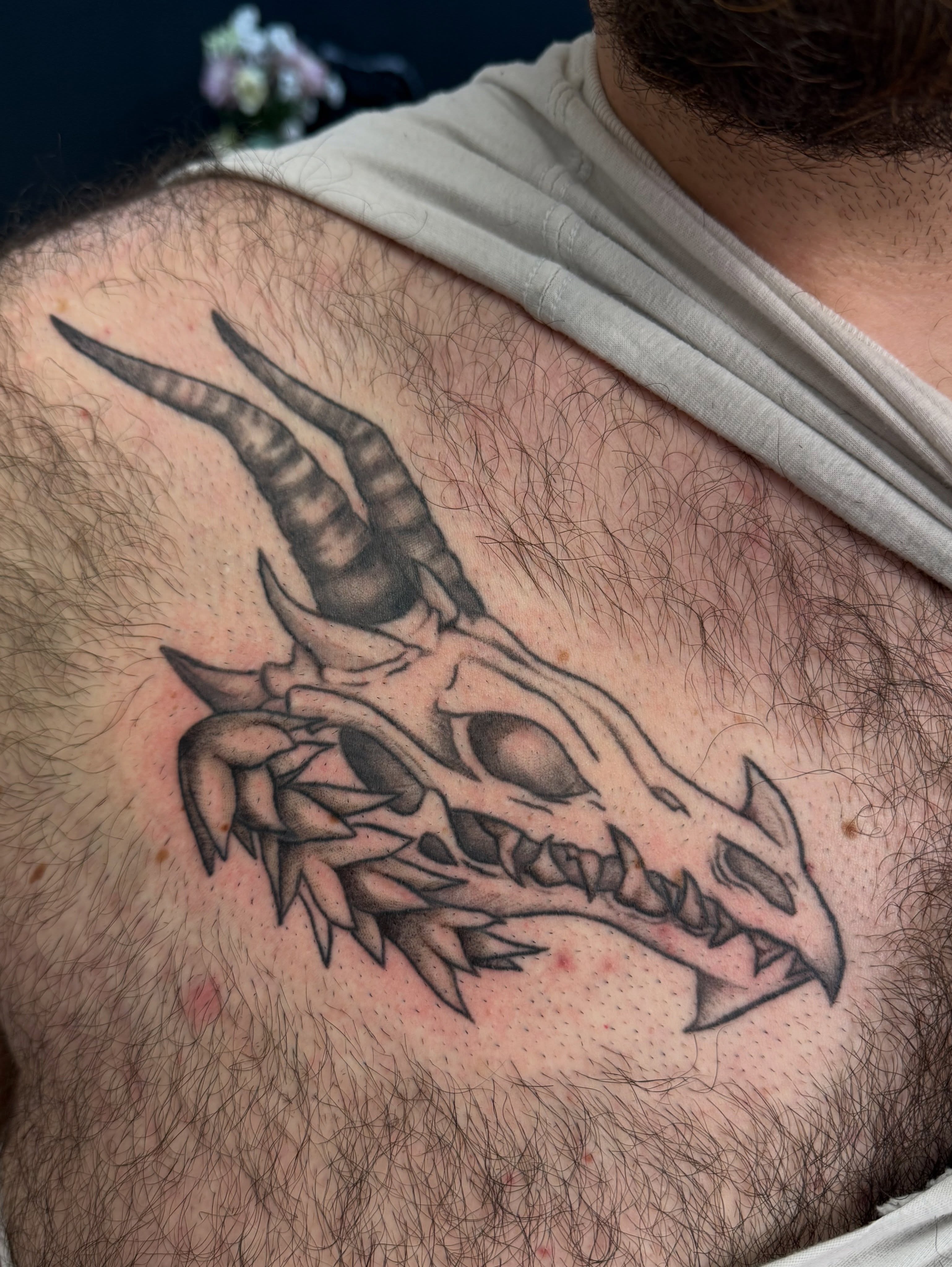 Dragon skull black and grey tattoo on the chest by Shay - Mandeville Tattoo Artist