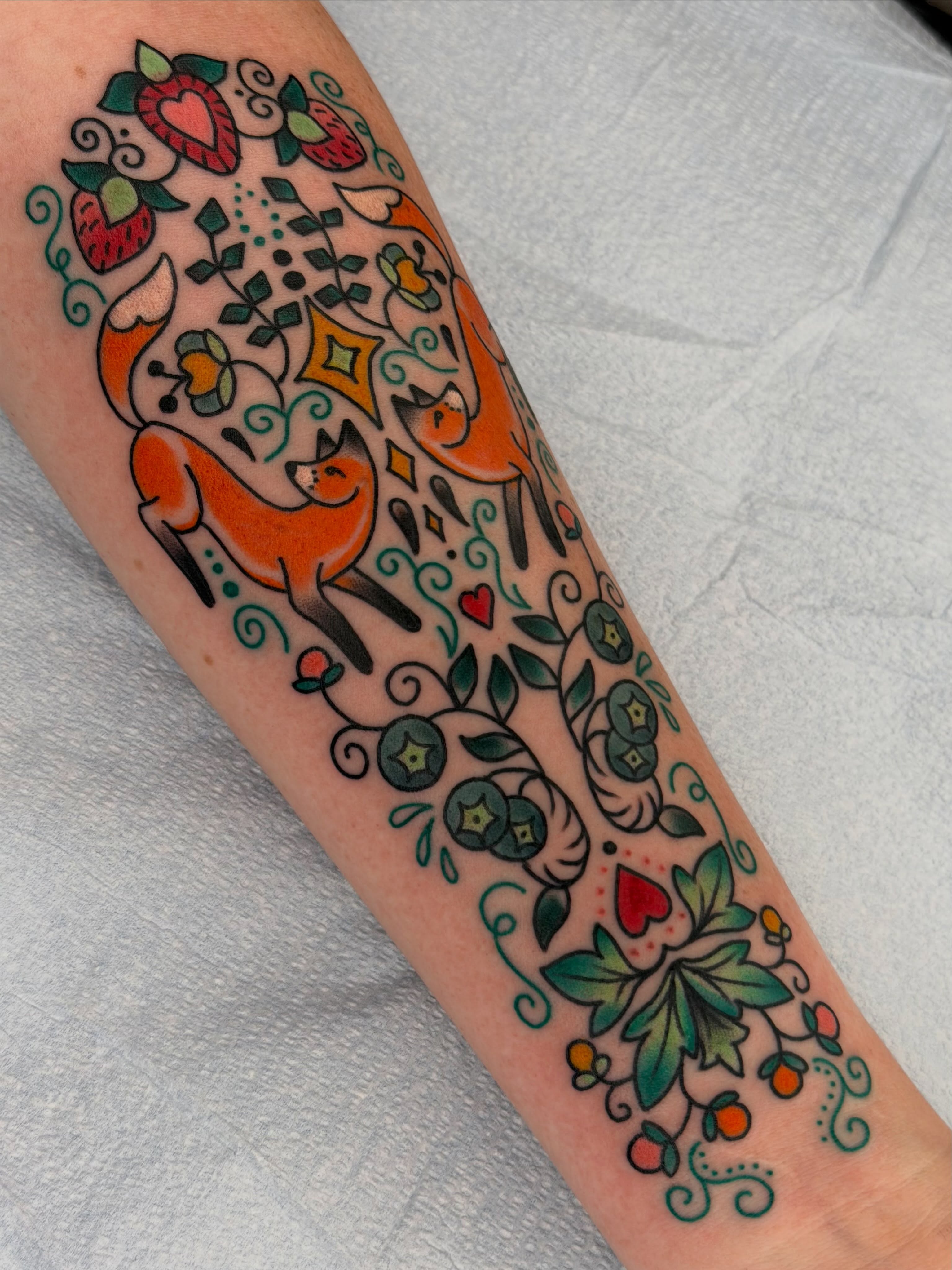 Foxes and berries new school tattoo on the forearm by Beeker, Bellingham, Washington