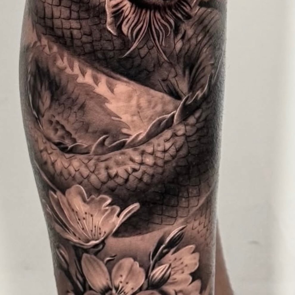 Dragon and flowers realism tattoo on the forearm by Elijah Tattoos, San Diego, California