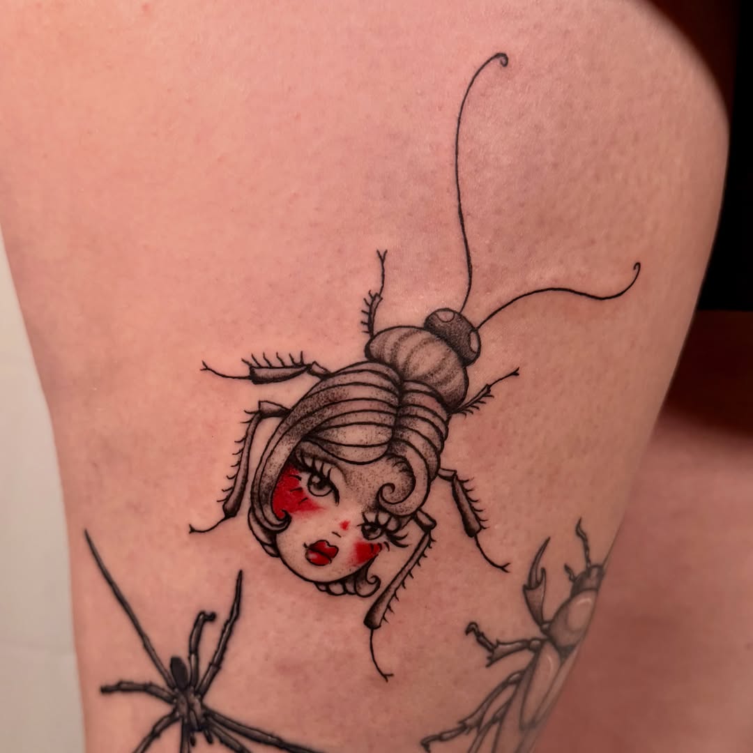 Roach with human face black and grey tattoo on the thigh by tattooz by megz