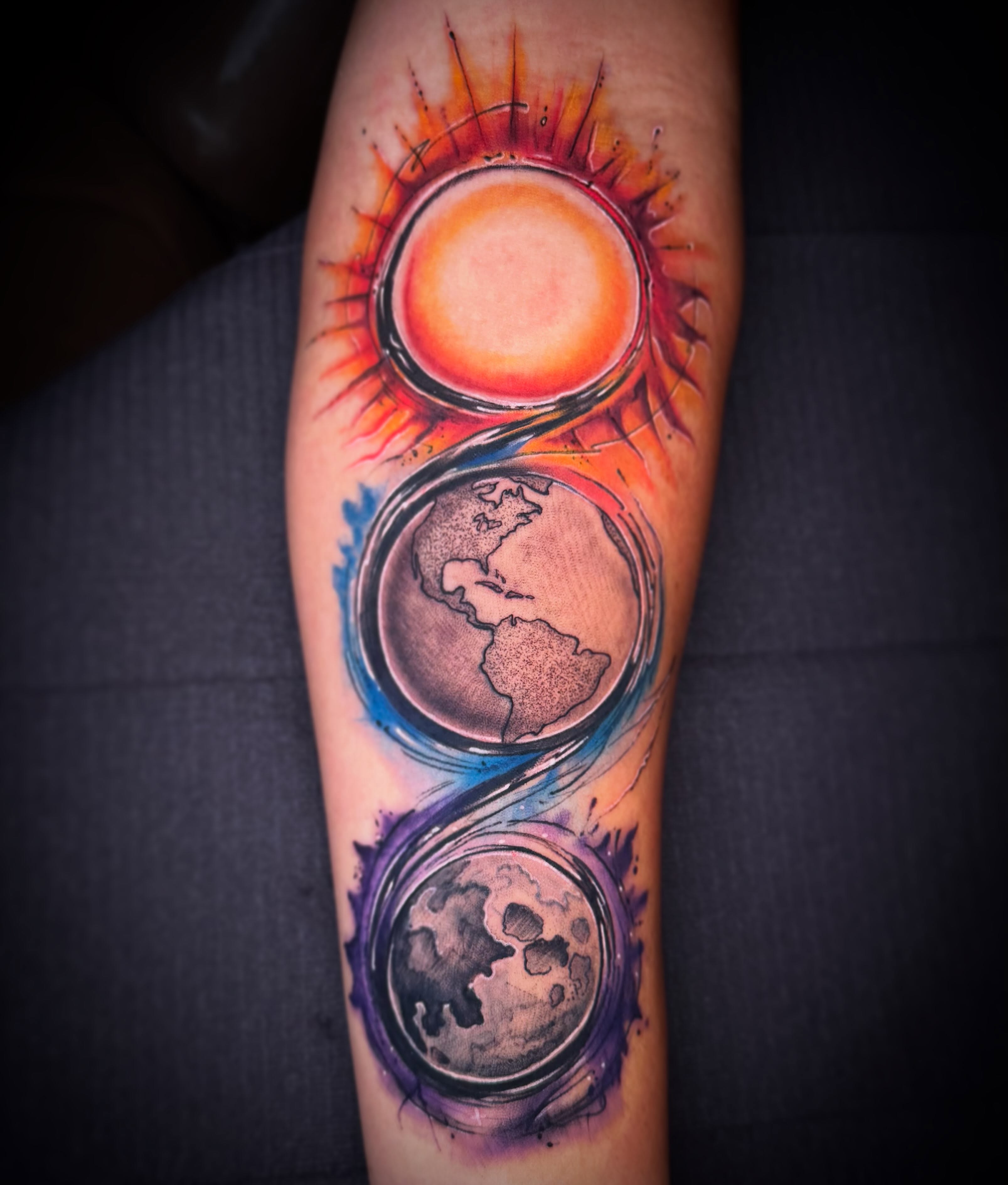 Sun, moon, earth watercolor tattoo on the forearm by Eric Zuluaga