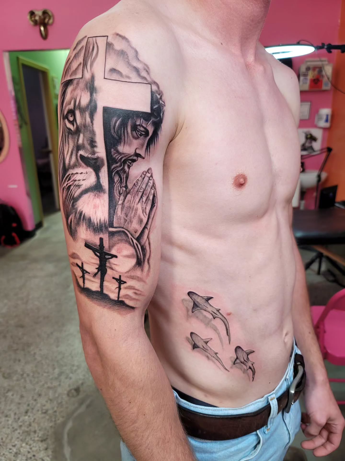 Lion and Jesus realism tattoo on the upper arm by Mary Lefeau
