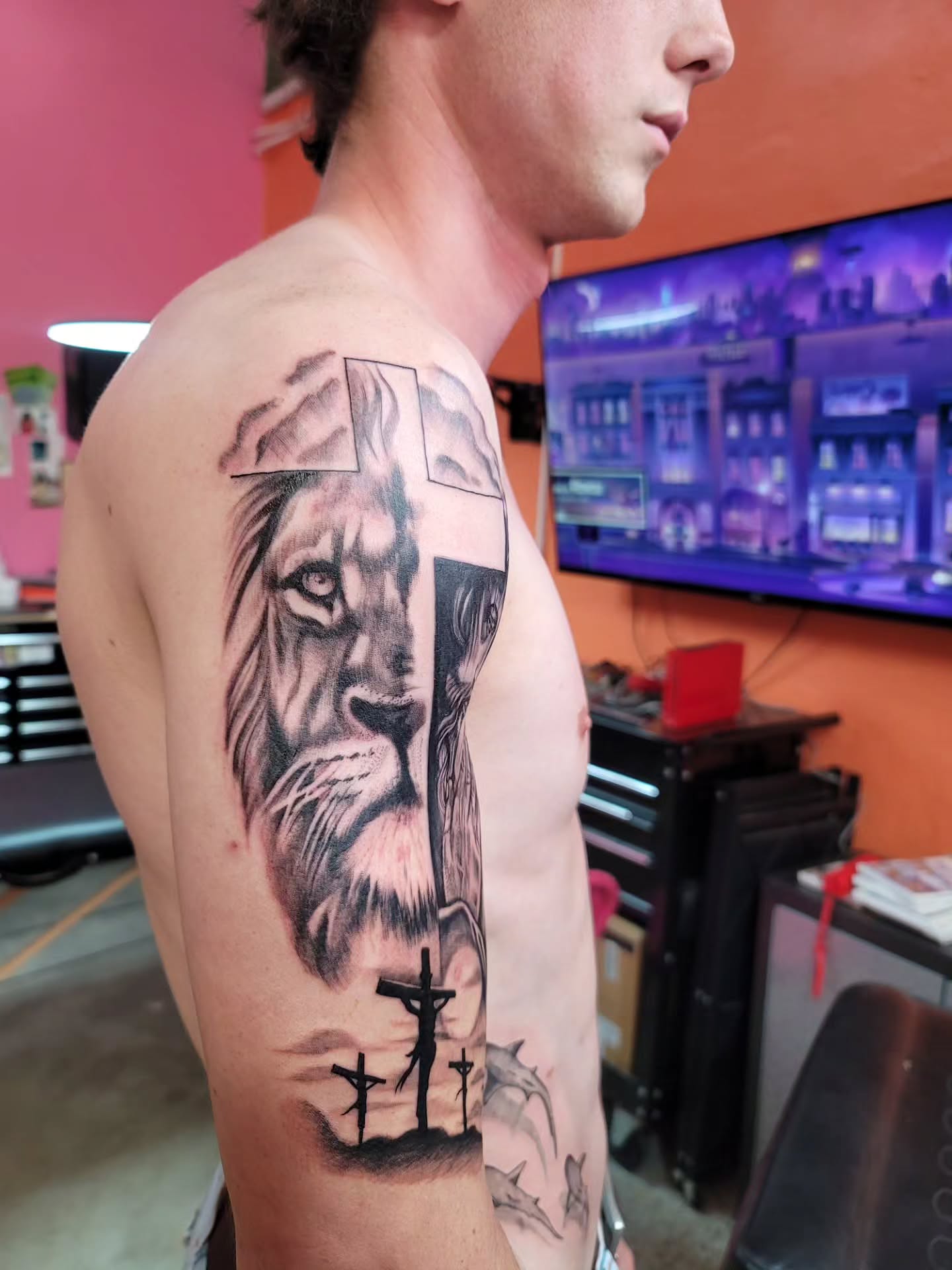 Lion and cross realism tattoo on the shoulder by Mary Lefeau