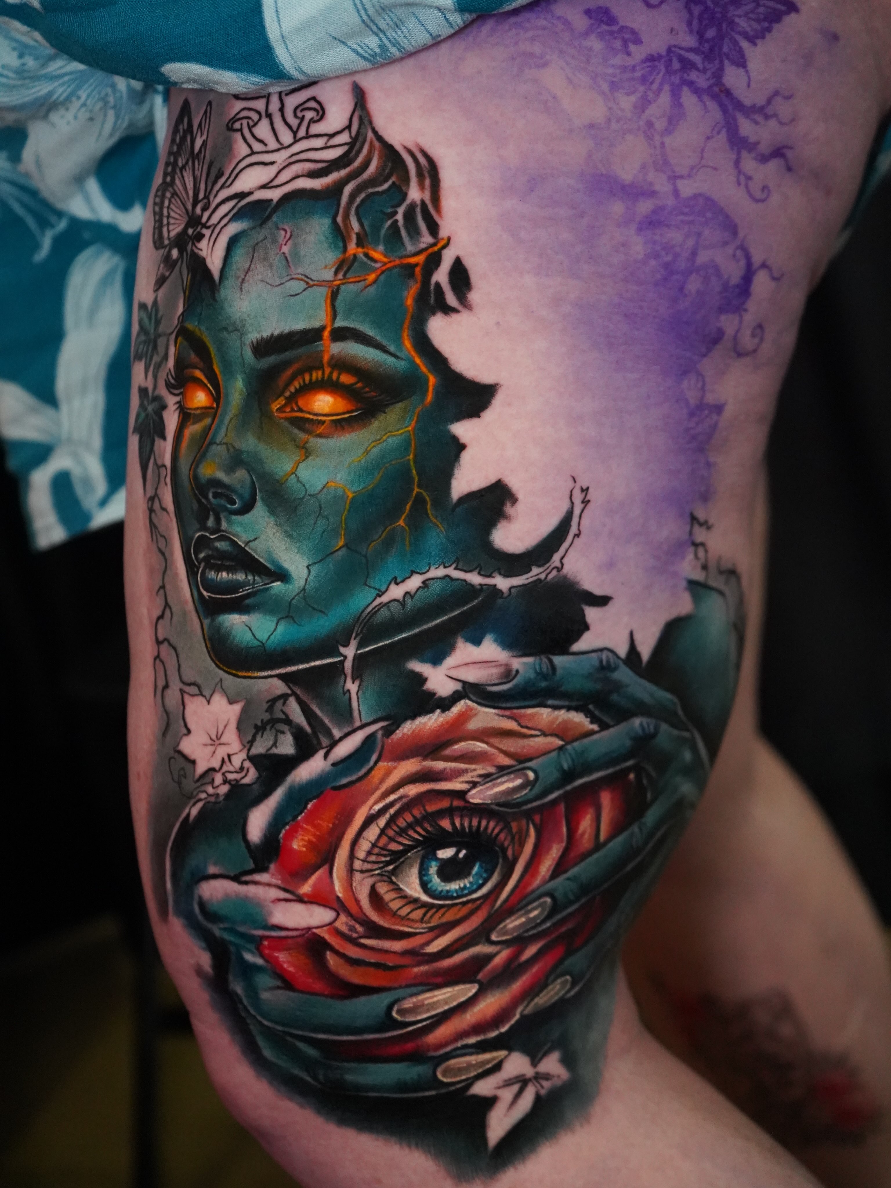 Woman with cracked face and rose dark realism tattoo on the thigh by Eric Zuluaga