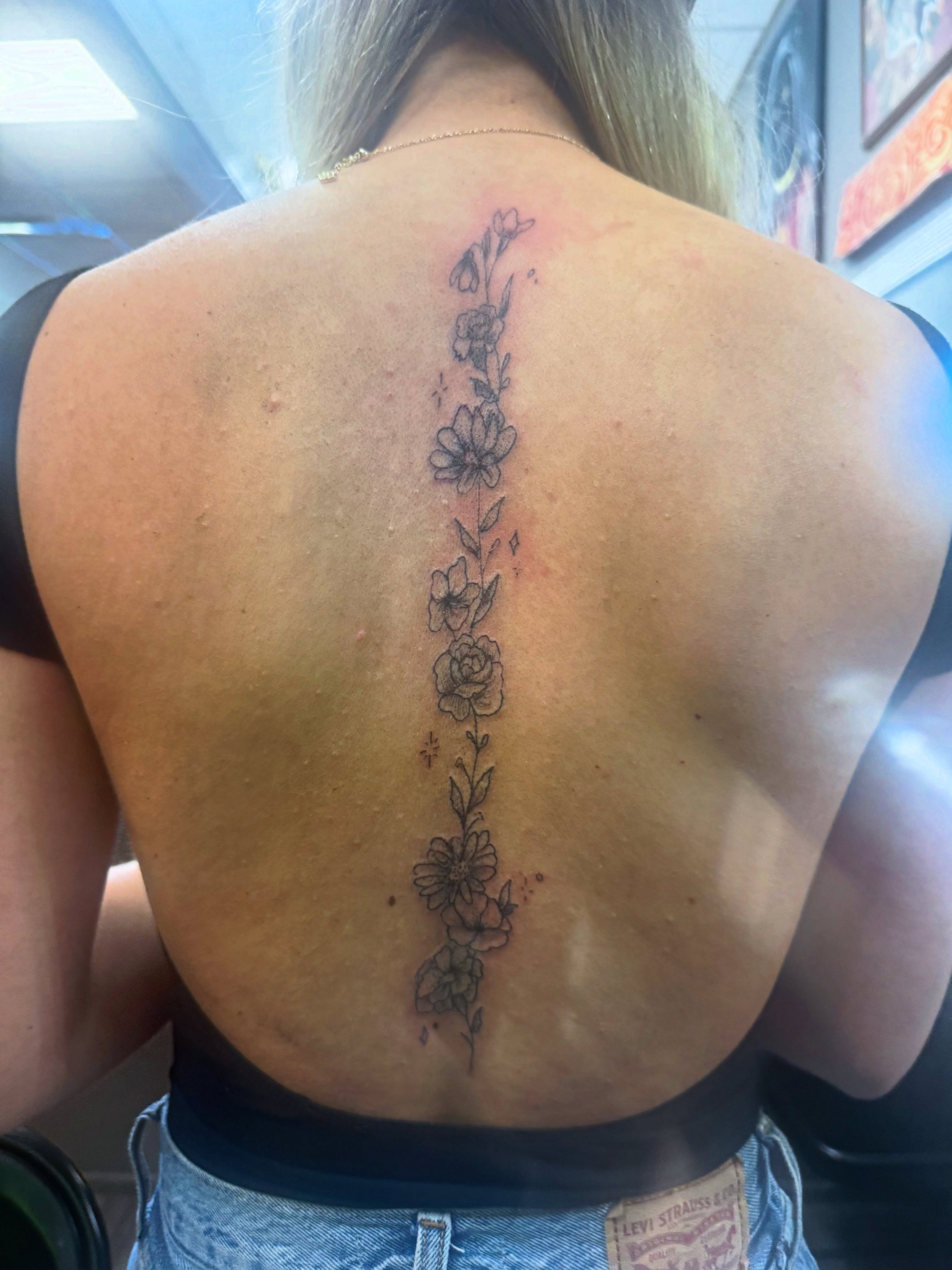 Floral arrangement black and grey tattoo on the back by Lexy