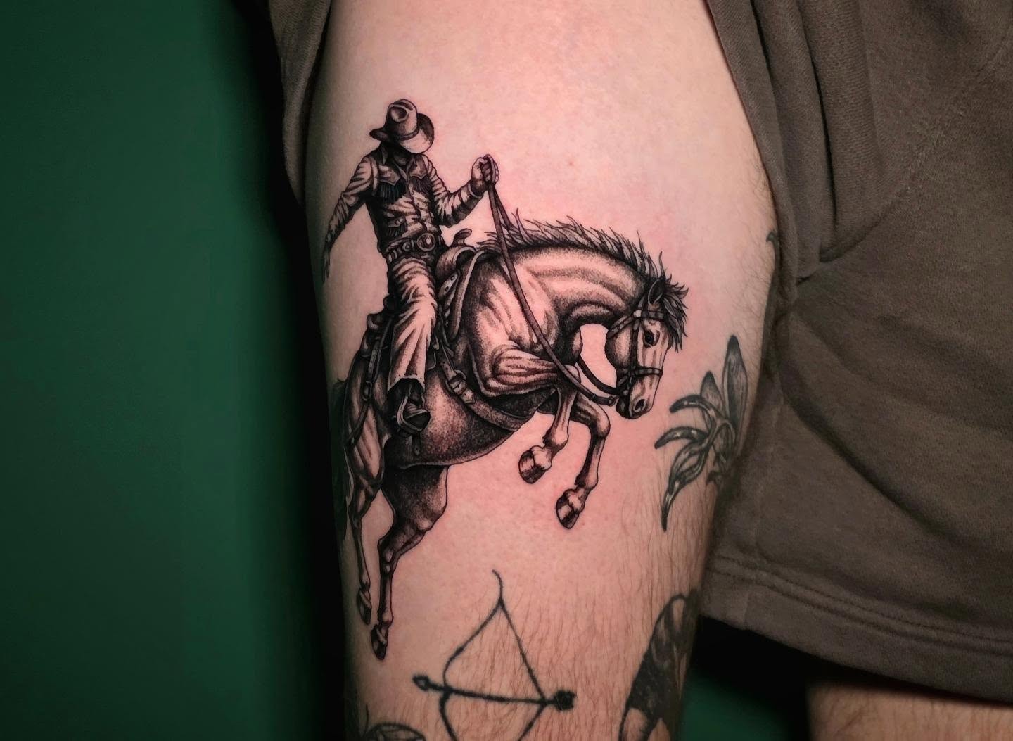 Cowboy riding horse black and grey tattoo on the forearm by Nick de Hoyos