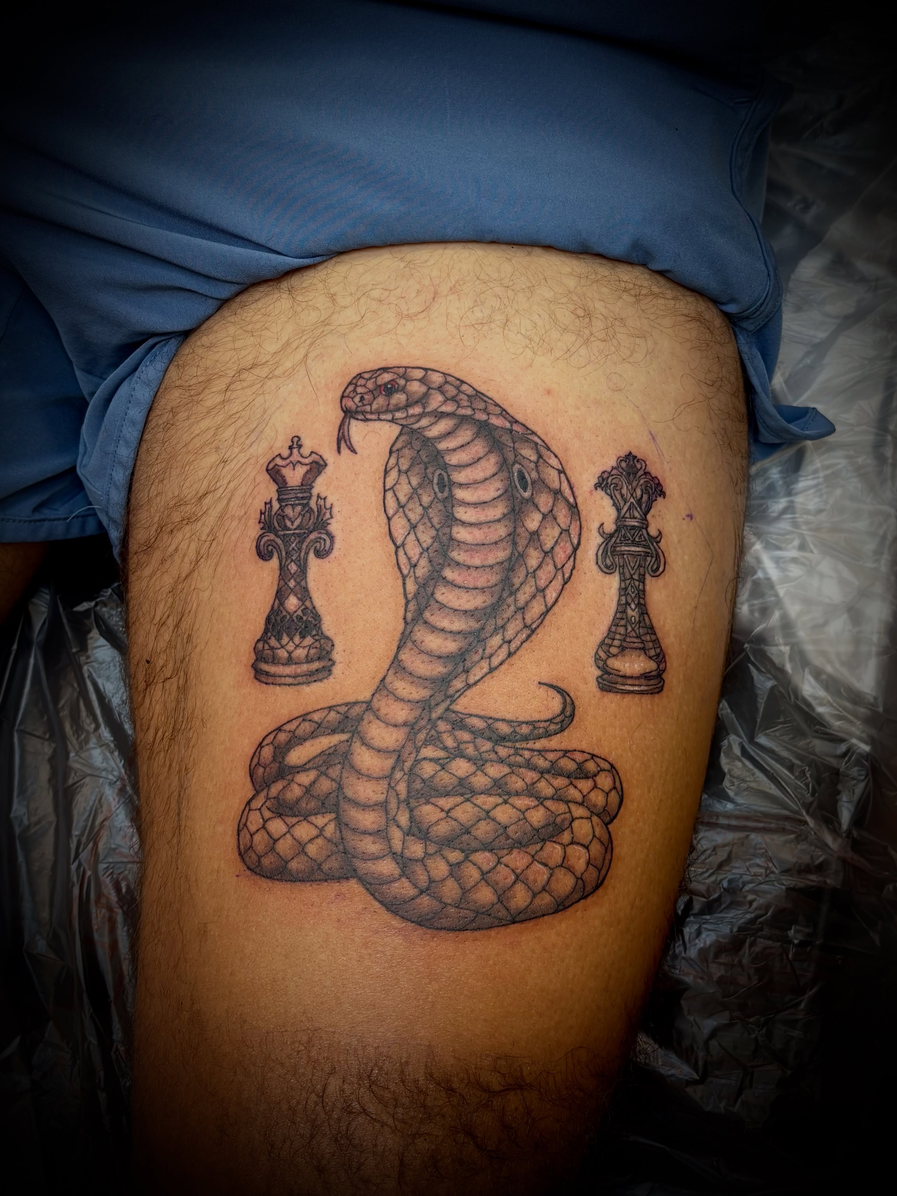 Snake and chess pieces realism tattoo on the thigh by Thom Johns-Green