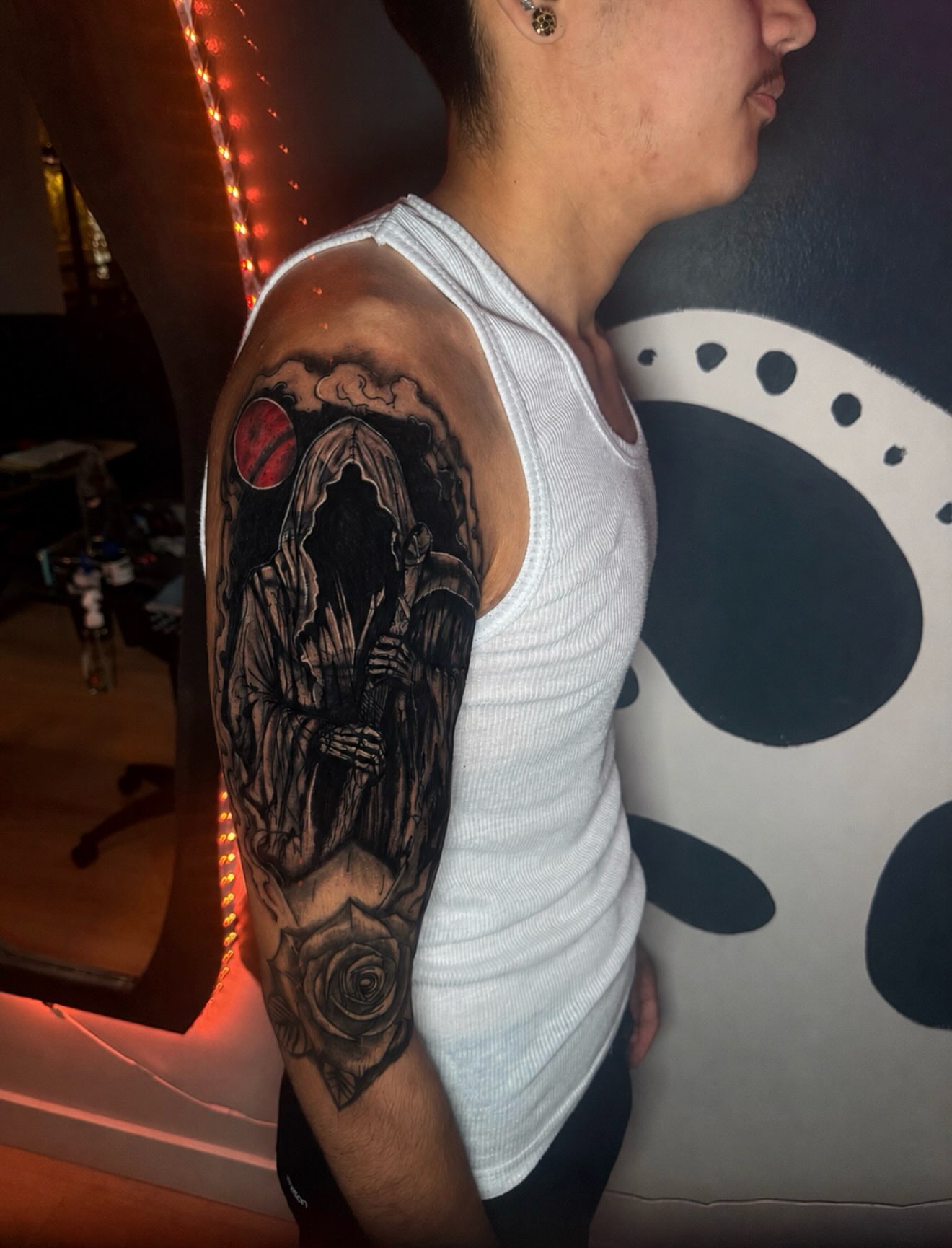 Grim reaper with rose realism tattoo on the upper arm by Kelsoink