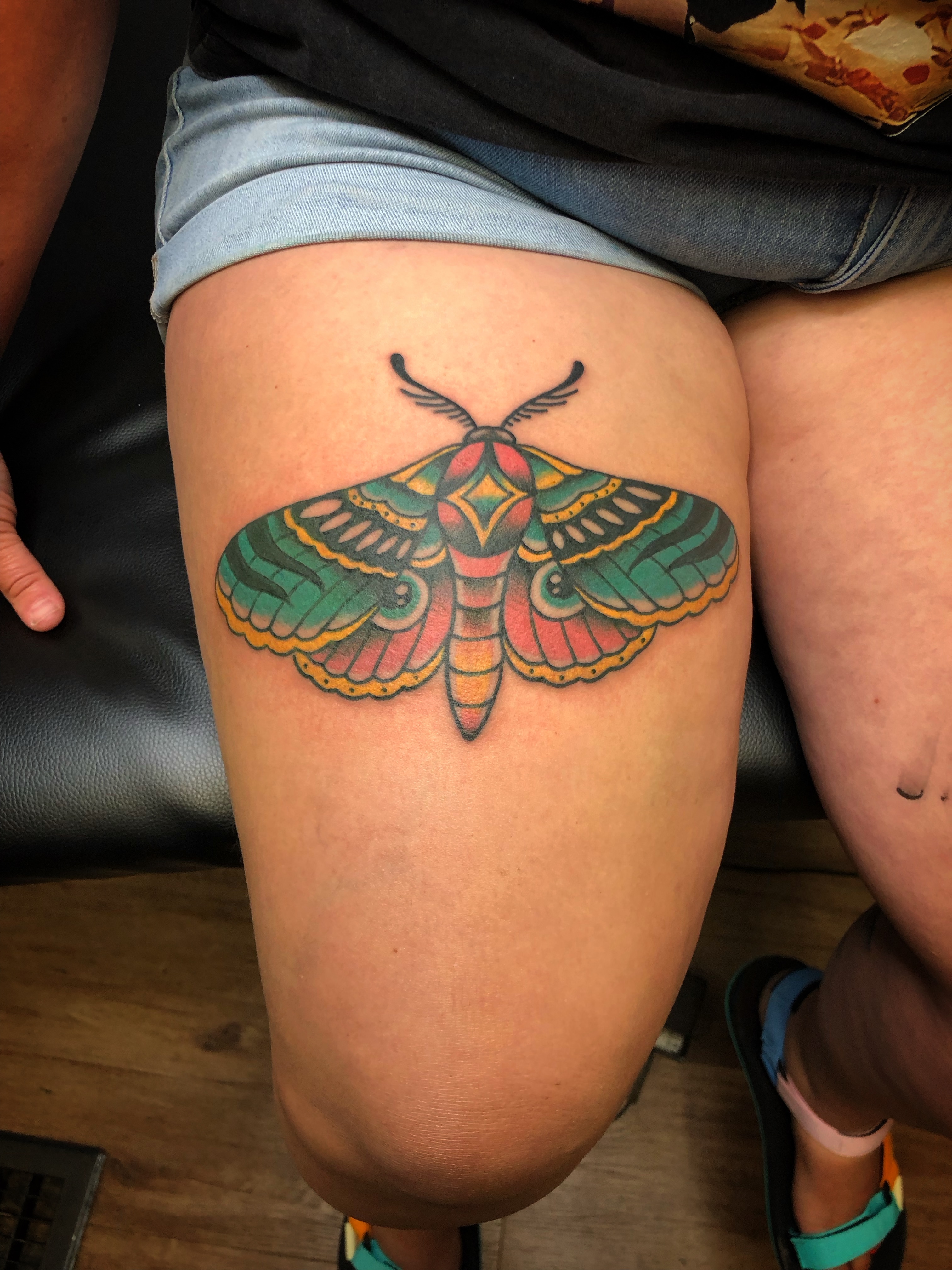 Moth American traditional tattoo on the thigh by Cee Marble