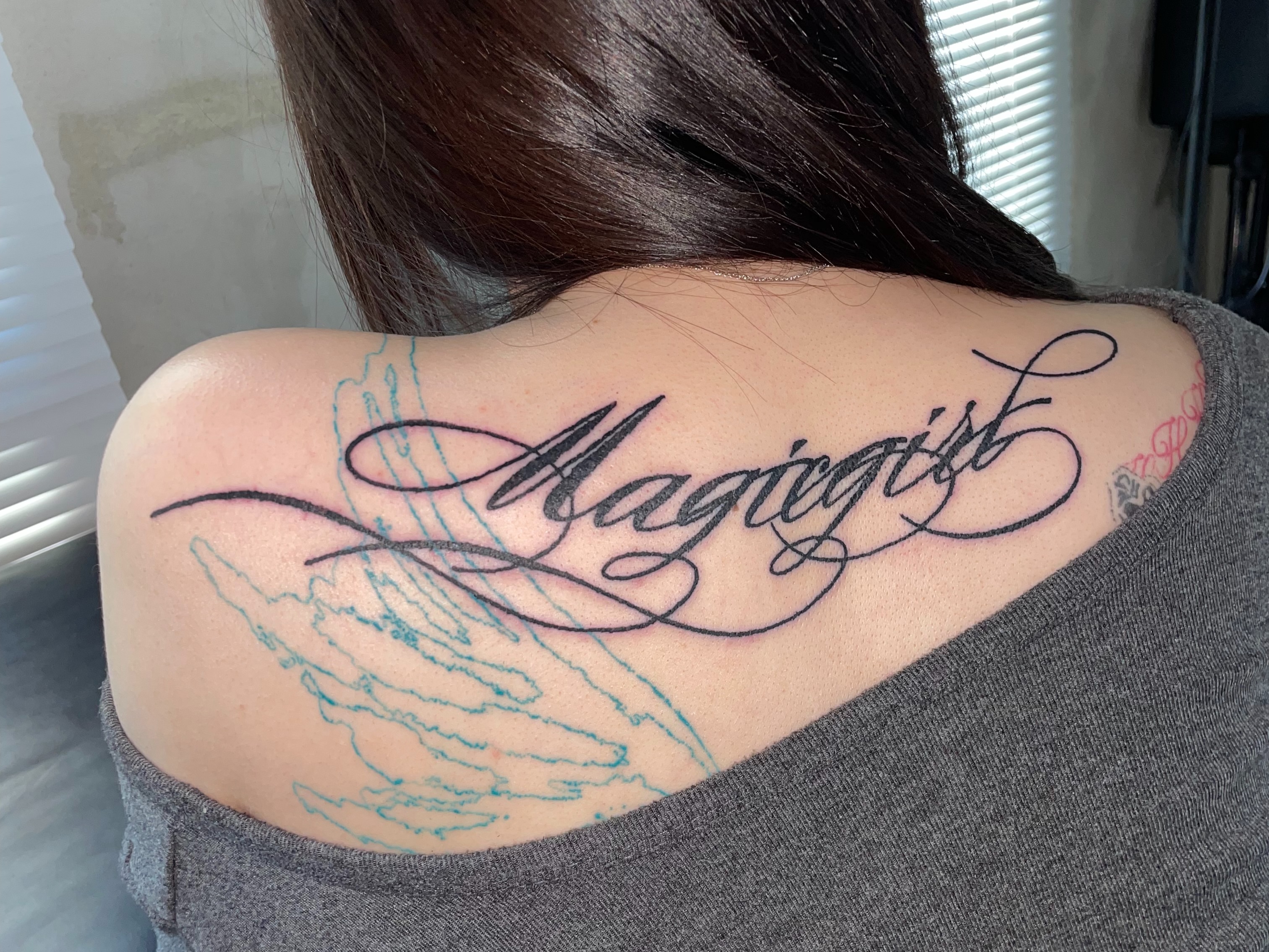 Magiegirl lettering script tattoo on the shoulder by eyeball