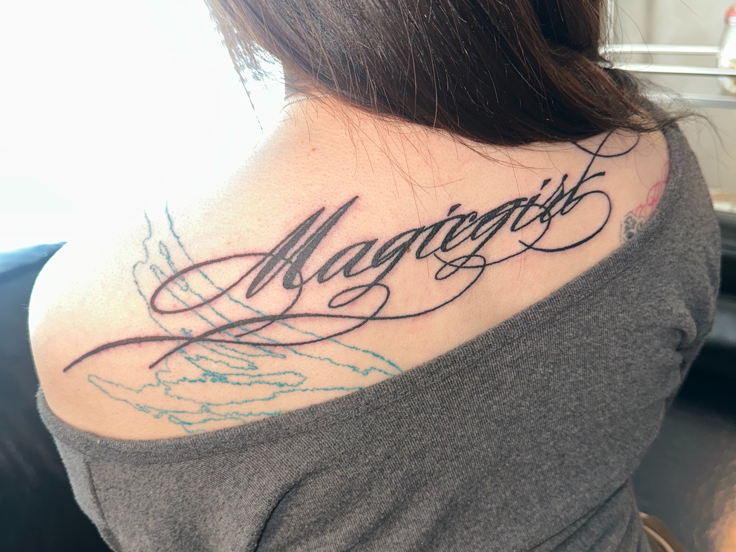 Magiegirl lettering script tattoo on the shoulder by eyeball