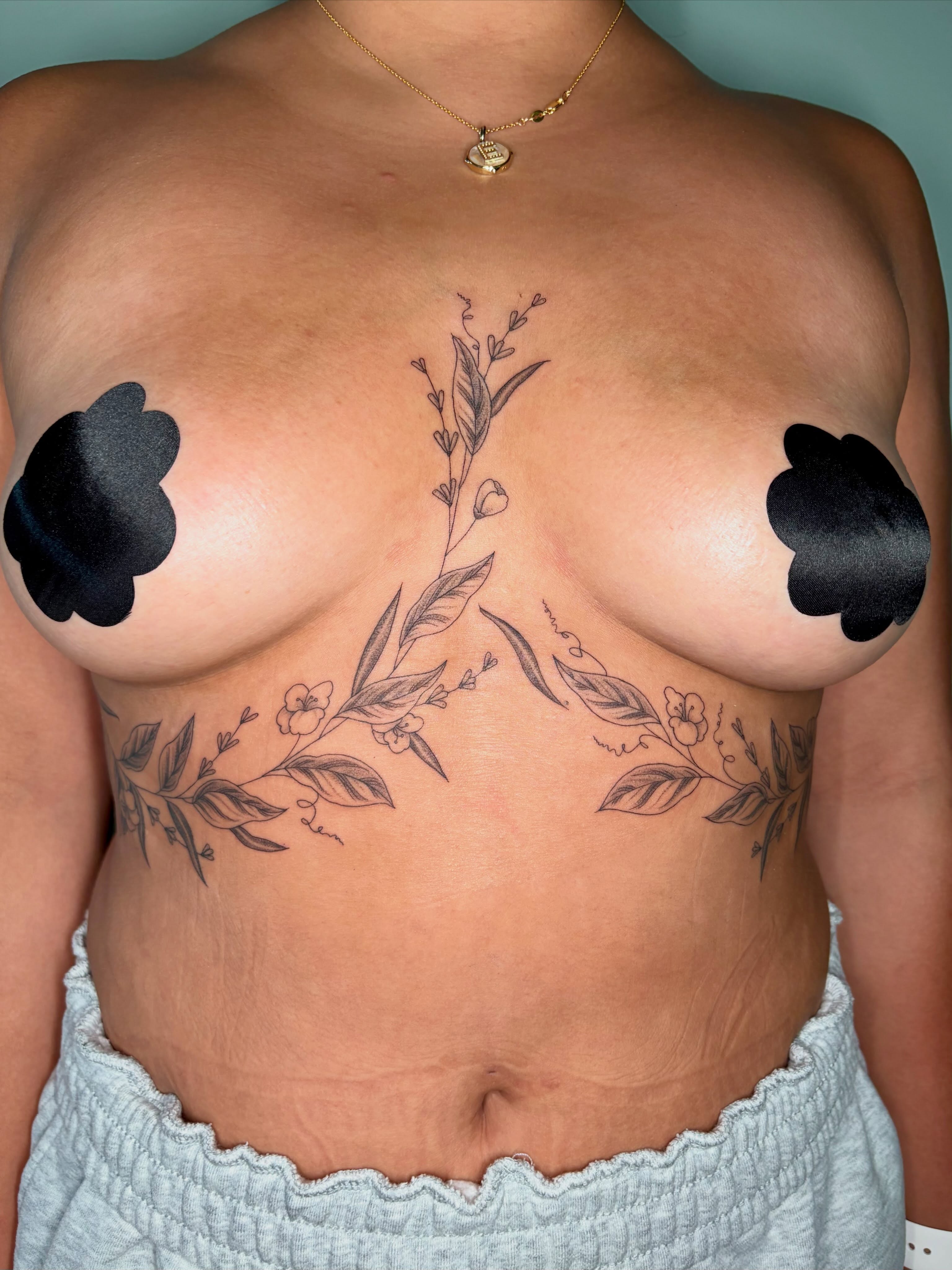 Floral vine black and grey tattoo on the chest by Sarah Roach