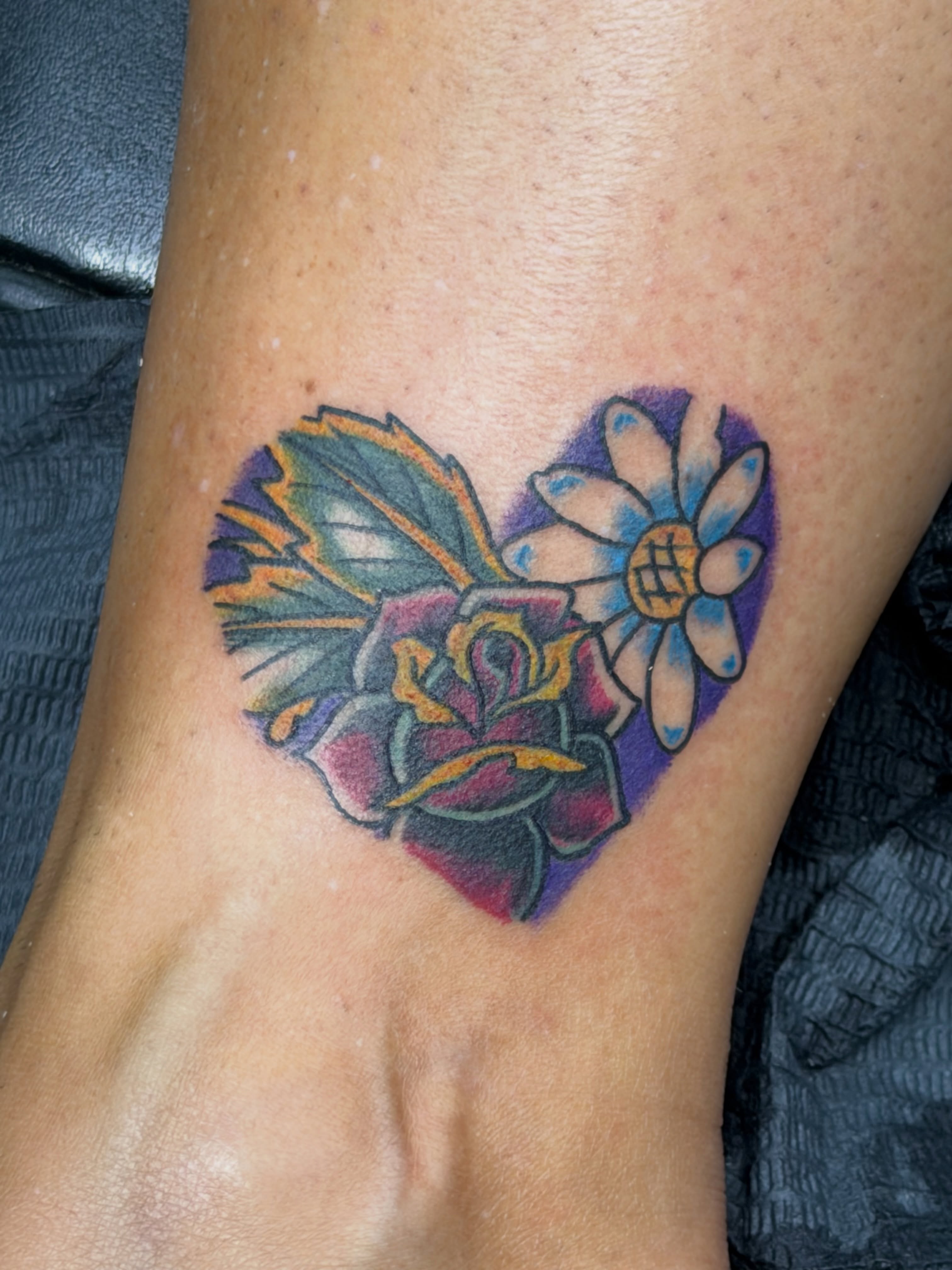 Heart with flower American traditional tattoo on the foot by Squid