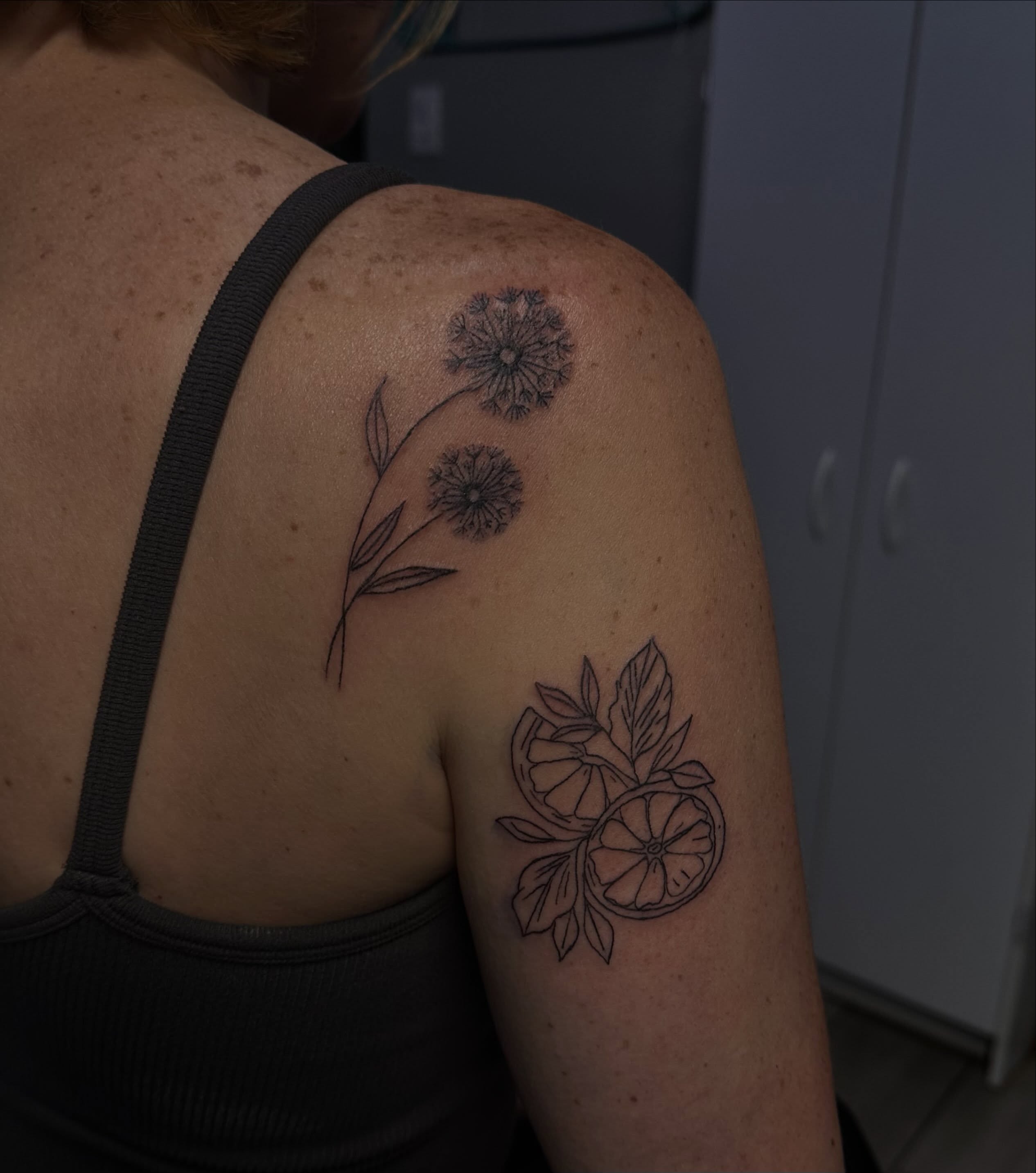 Dandelion and citrus black and grey tattoo on the shoulder by Marly Quinn