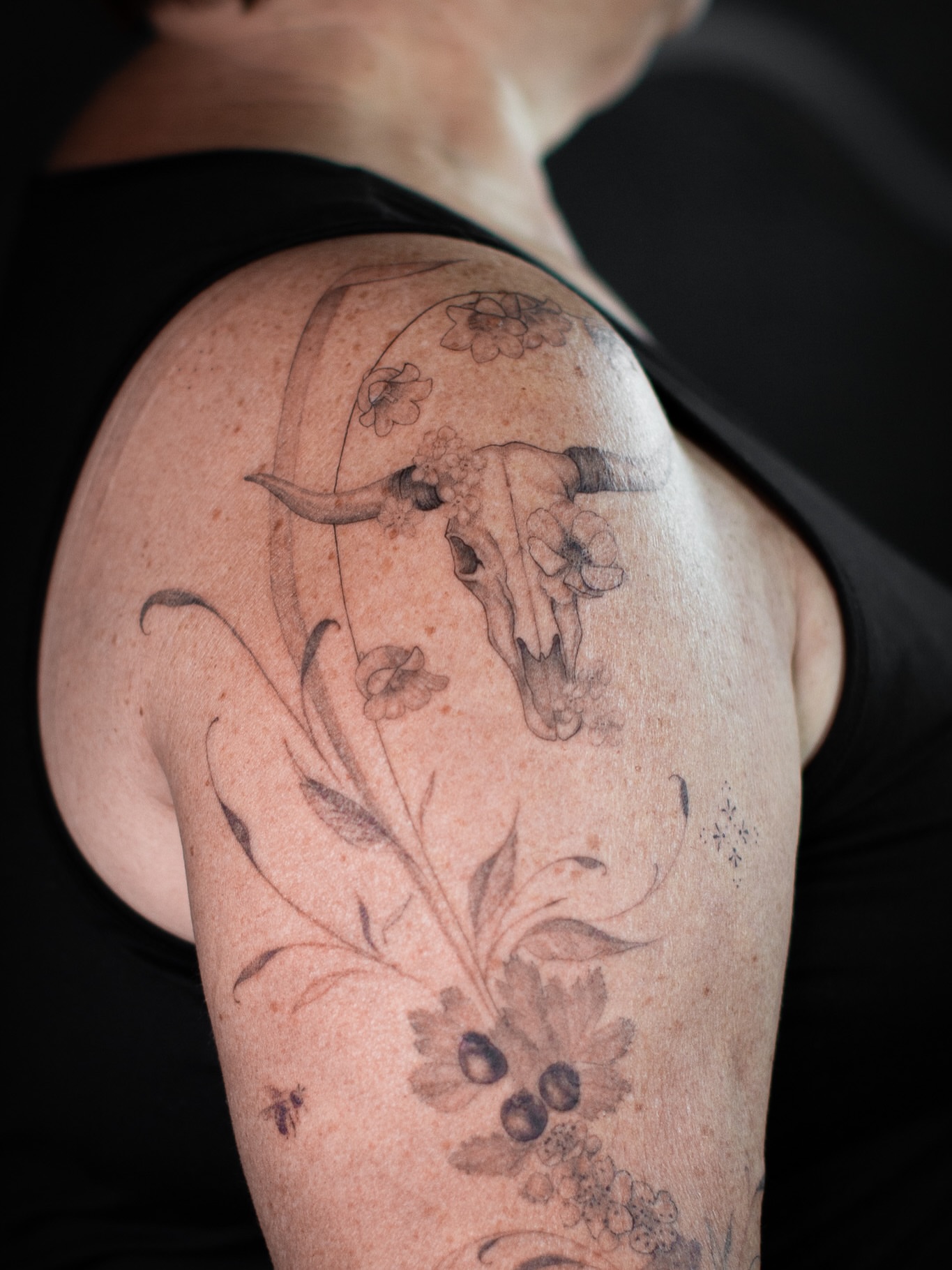 Bull skull with flowers realism tattoo on the shoulder by Aries Rising