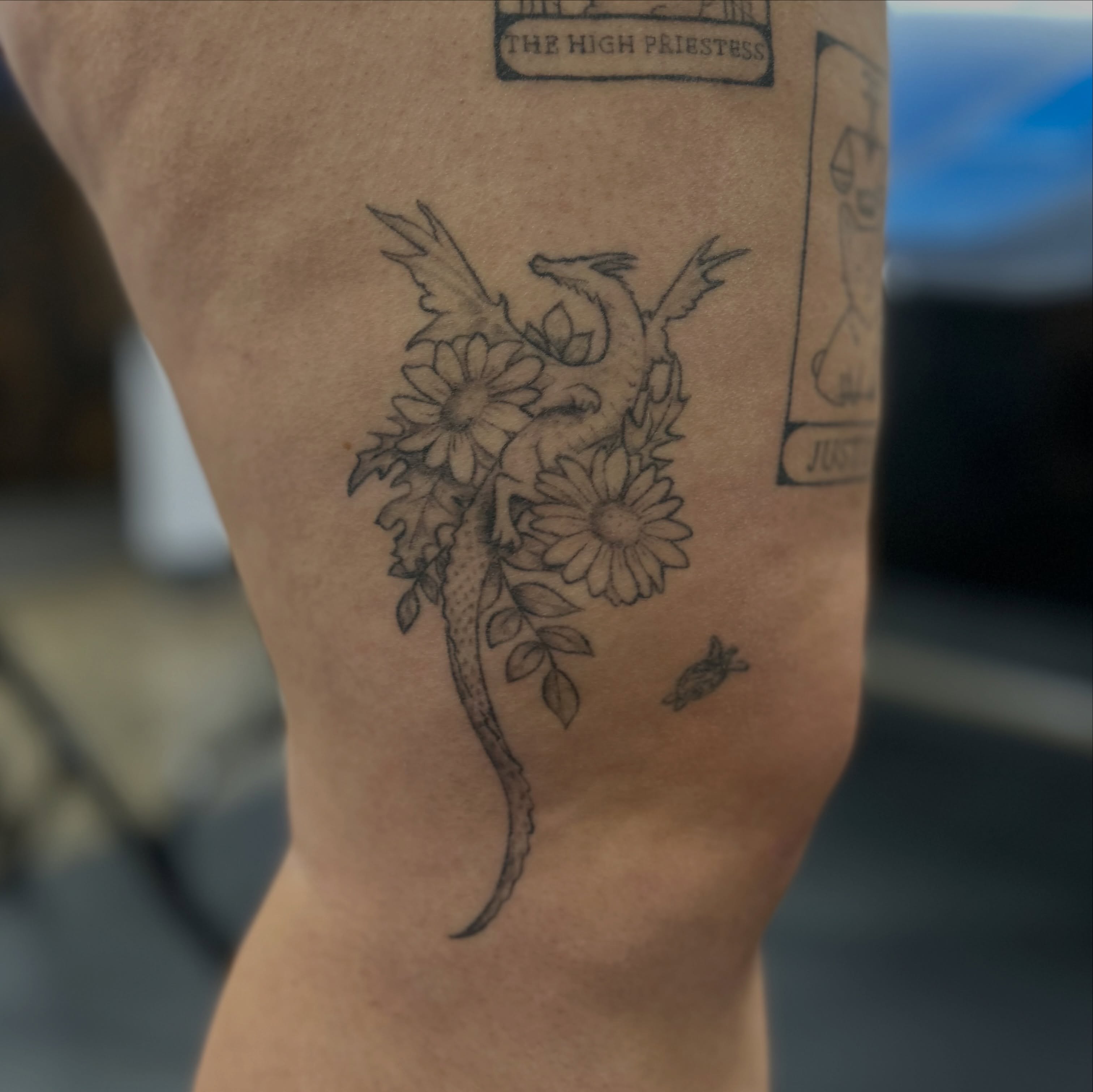 Dragon and flowers realism tattoo on the thigh by Natalie Johnson, Minneapolis, Minnesota