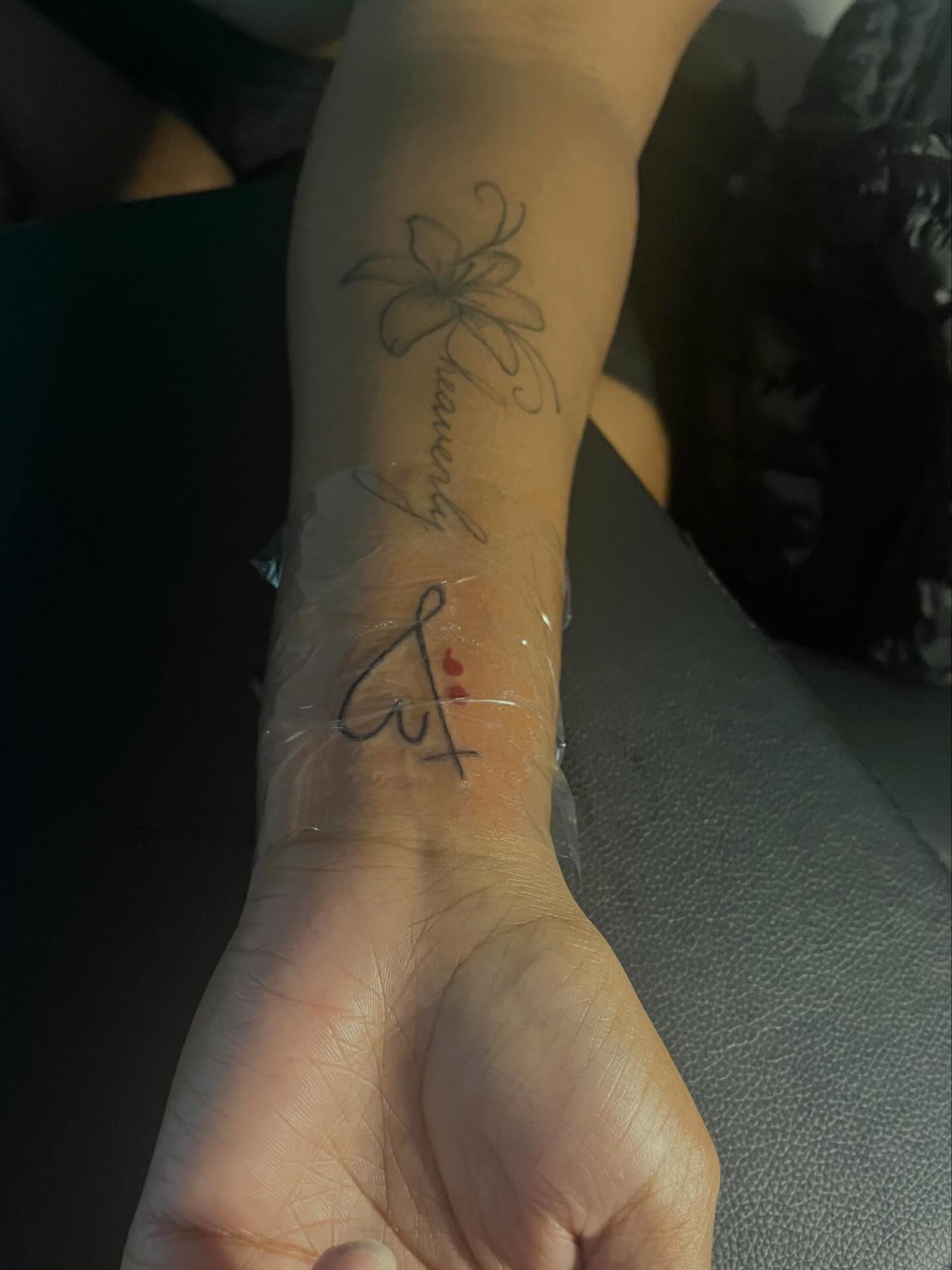 Flower and cursive text fine line tattoo on the forearm by π Westside
