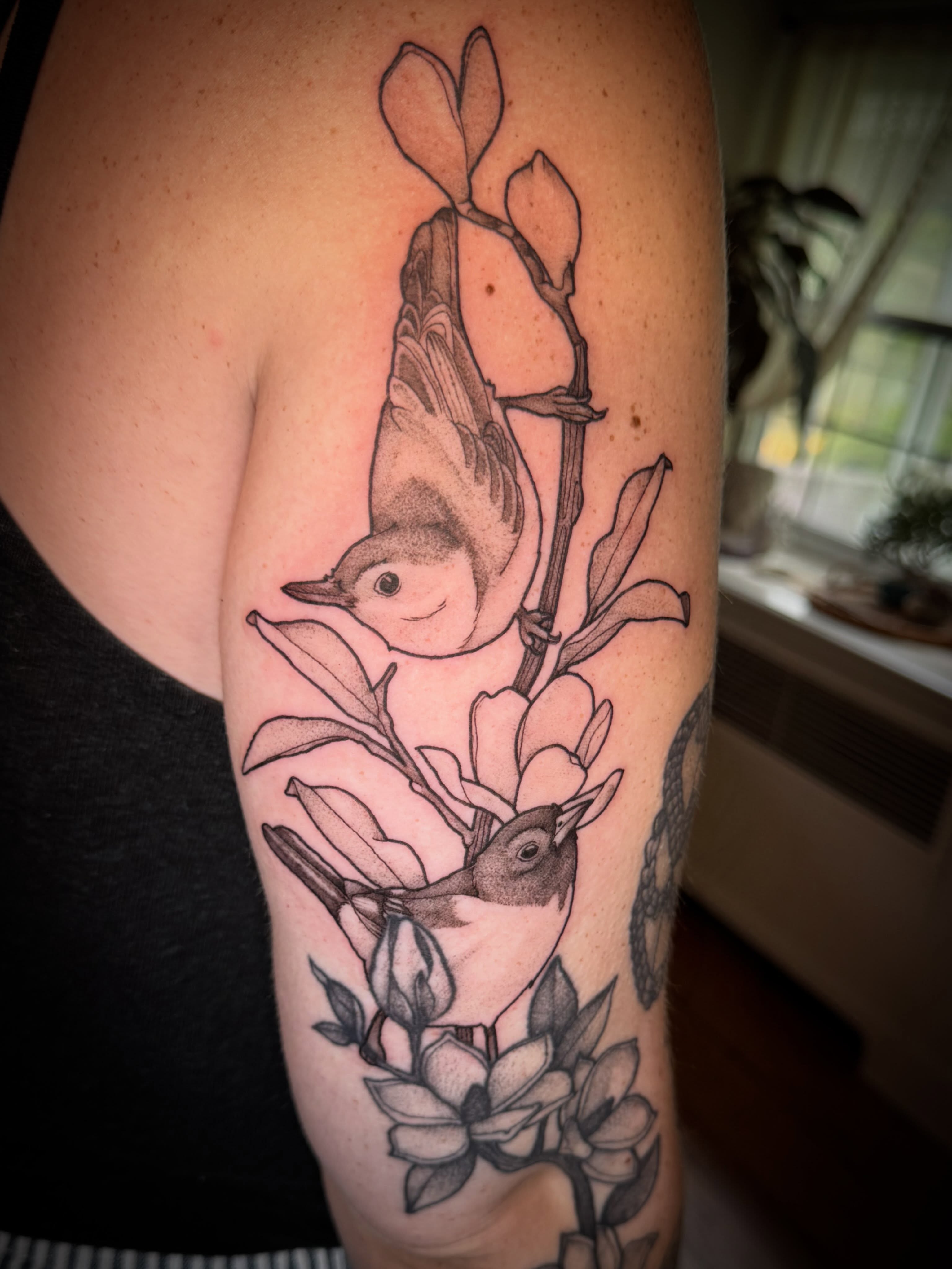 Birds and magnolia flowers realism tattoo on the upper arm by Tattoos by Alex