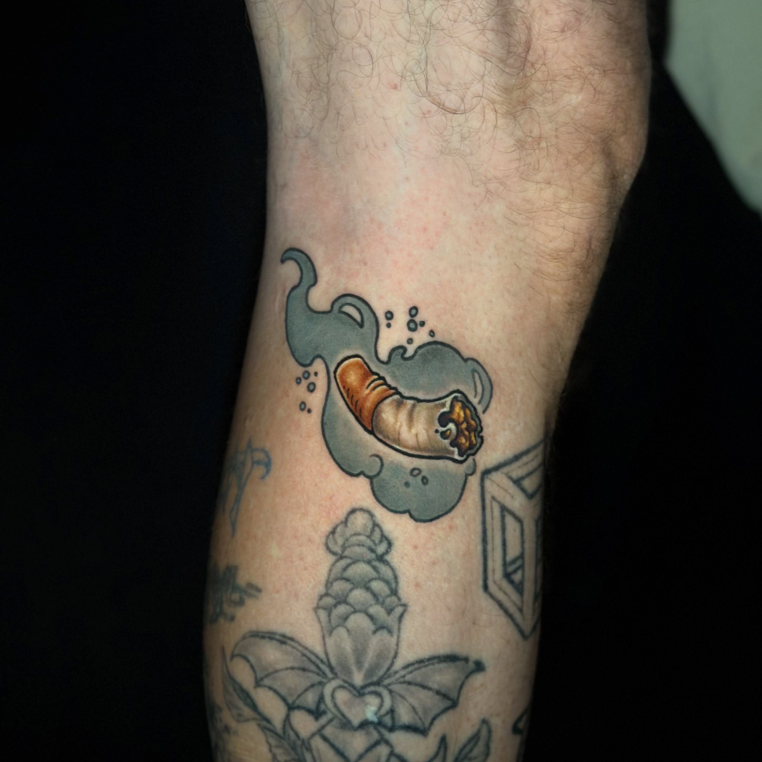 Cigarette and smoke American traditional tattoo on the forearm by Trista Bettfreund (Birdy)
