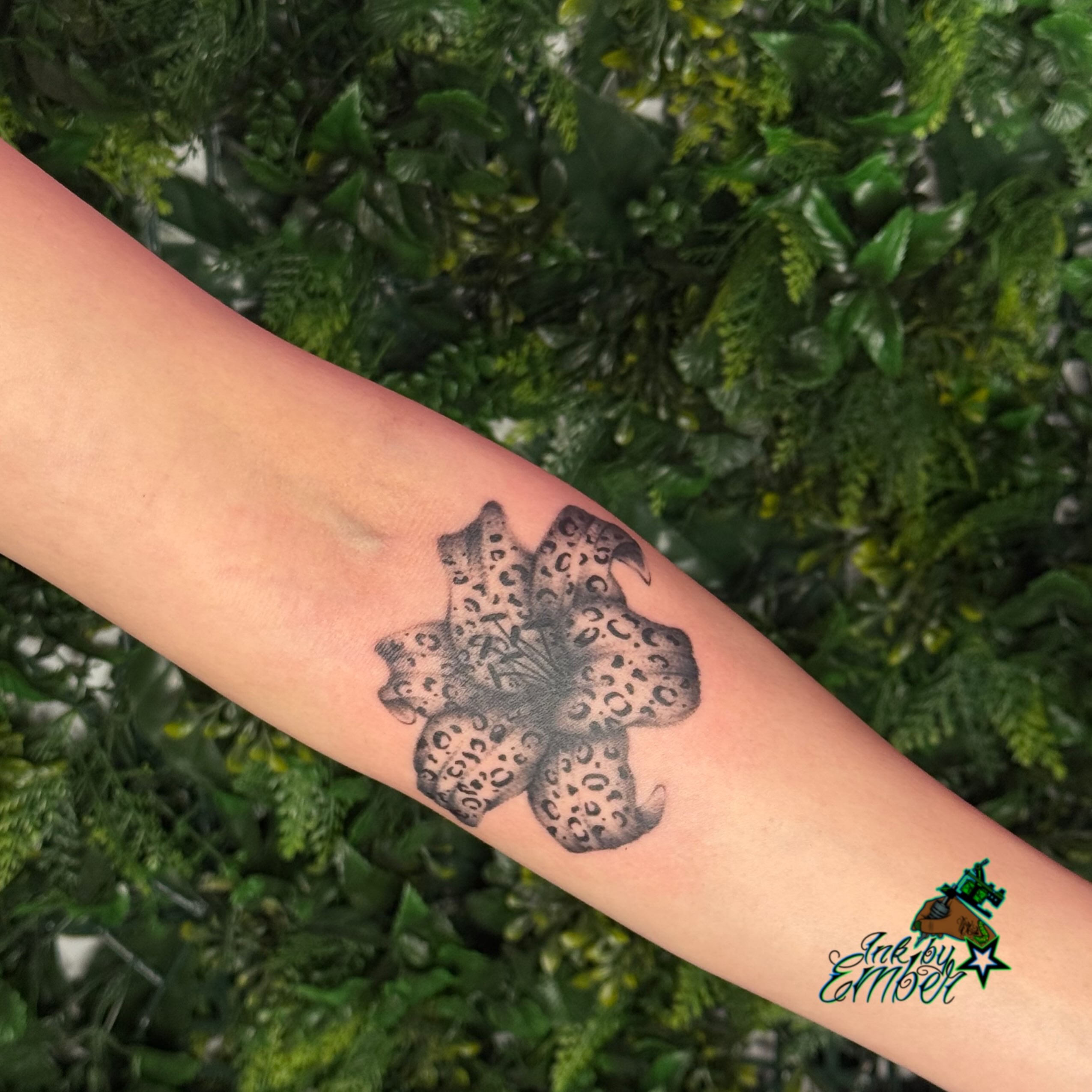 Leopard print flower black and grey tattoo on the forearm by Ember