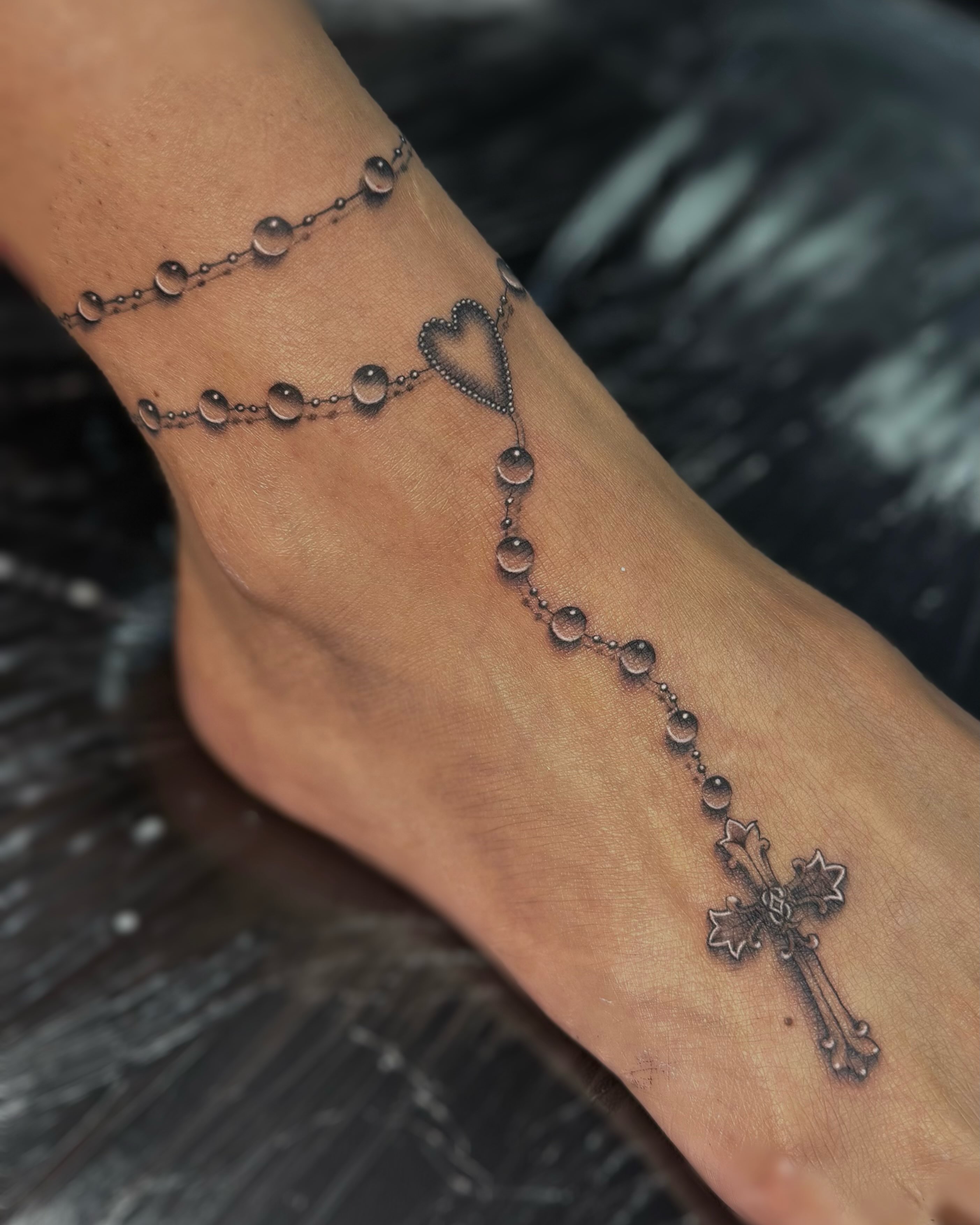 Rosary black and grey tattoo on the foot by Jas Knight