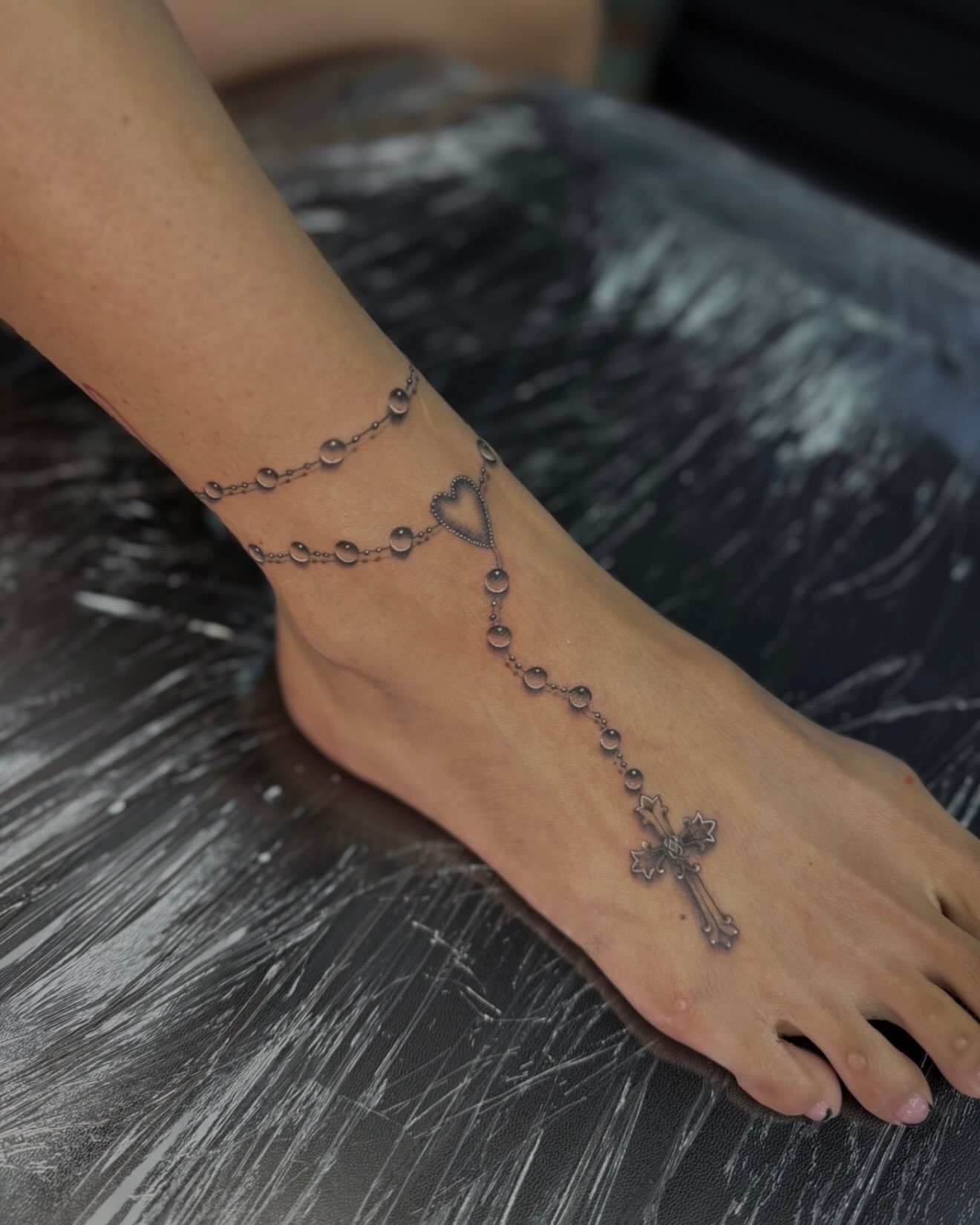 Rosary black and grey tattoo on the foot by Jas Knight