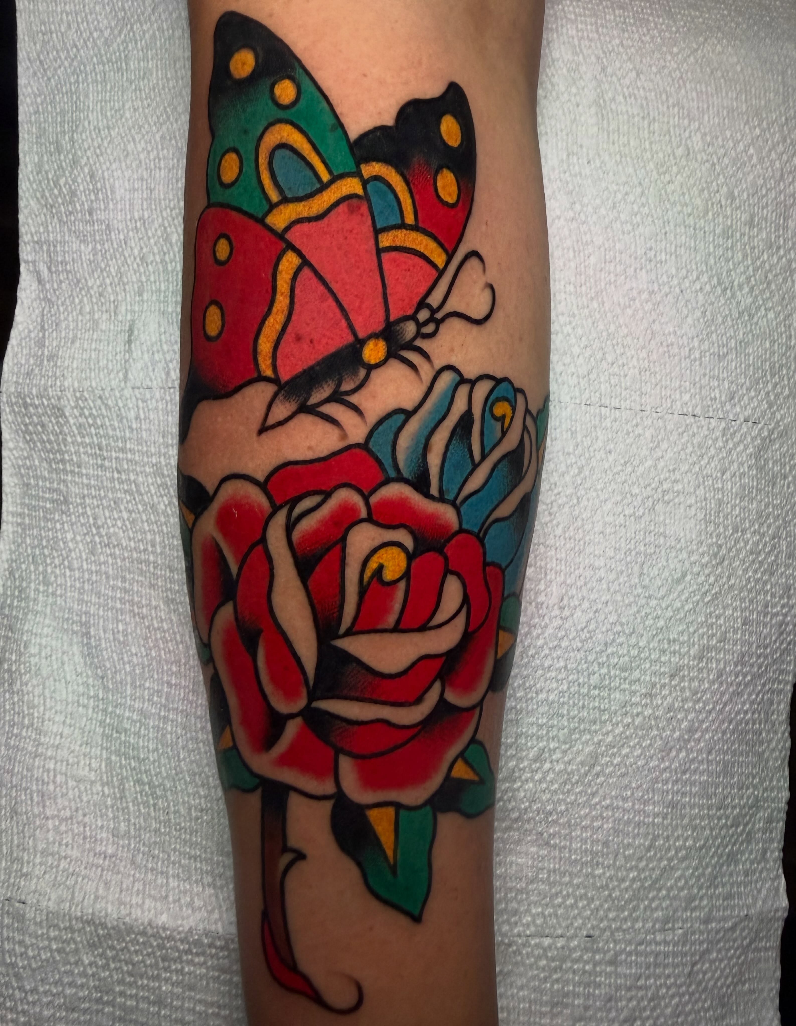 Butterfly and roses American traditional tattoo on the forearm by Don Lee