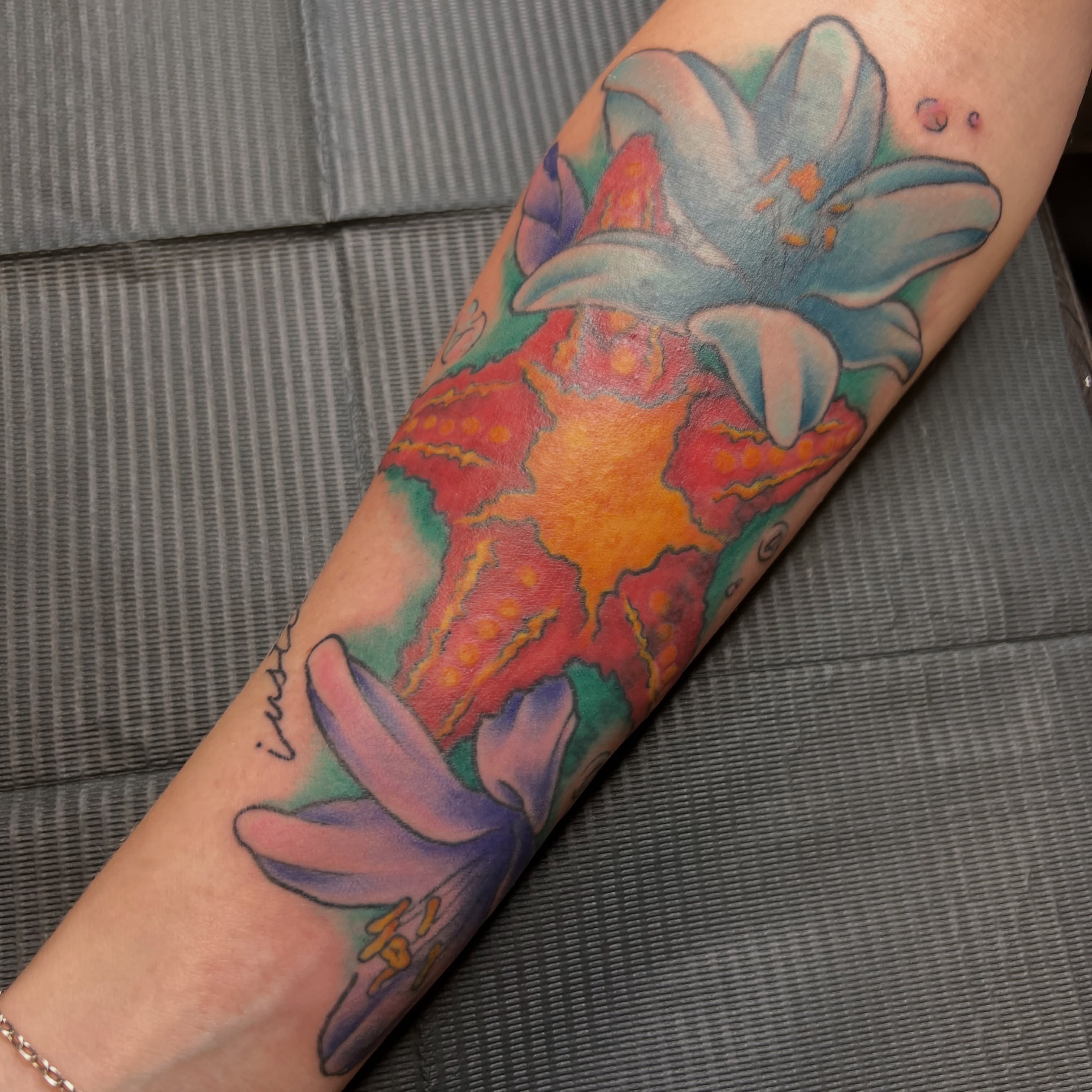 Lily and abstract background watercolor tattoo on the forearm by Dani McBay
