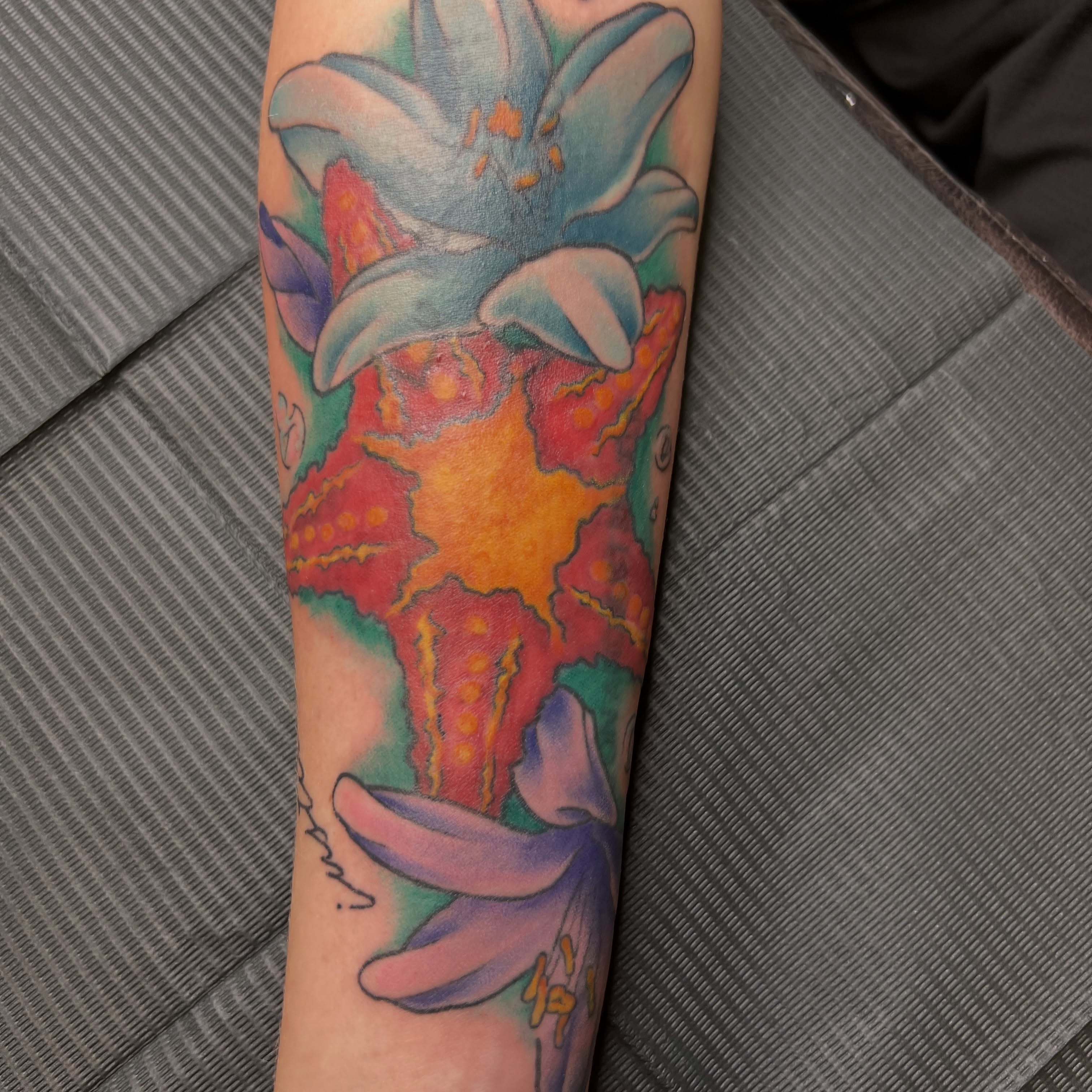 Lily watercolor tattoo on the forearm by Dani McBay