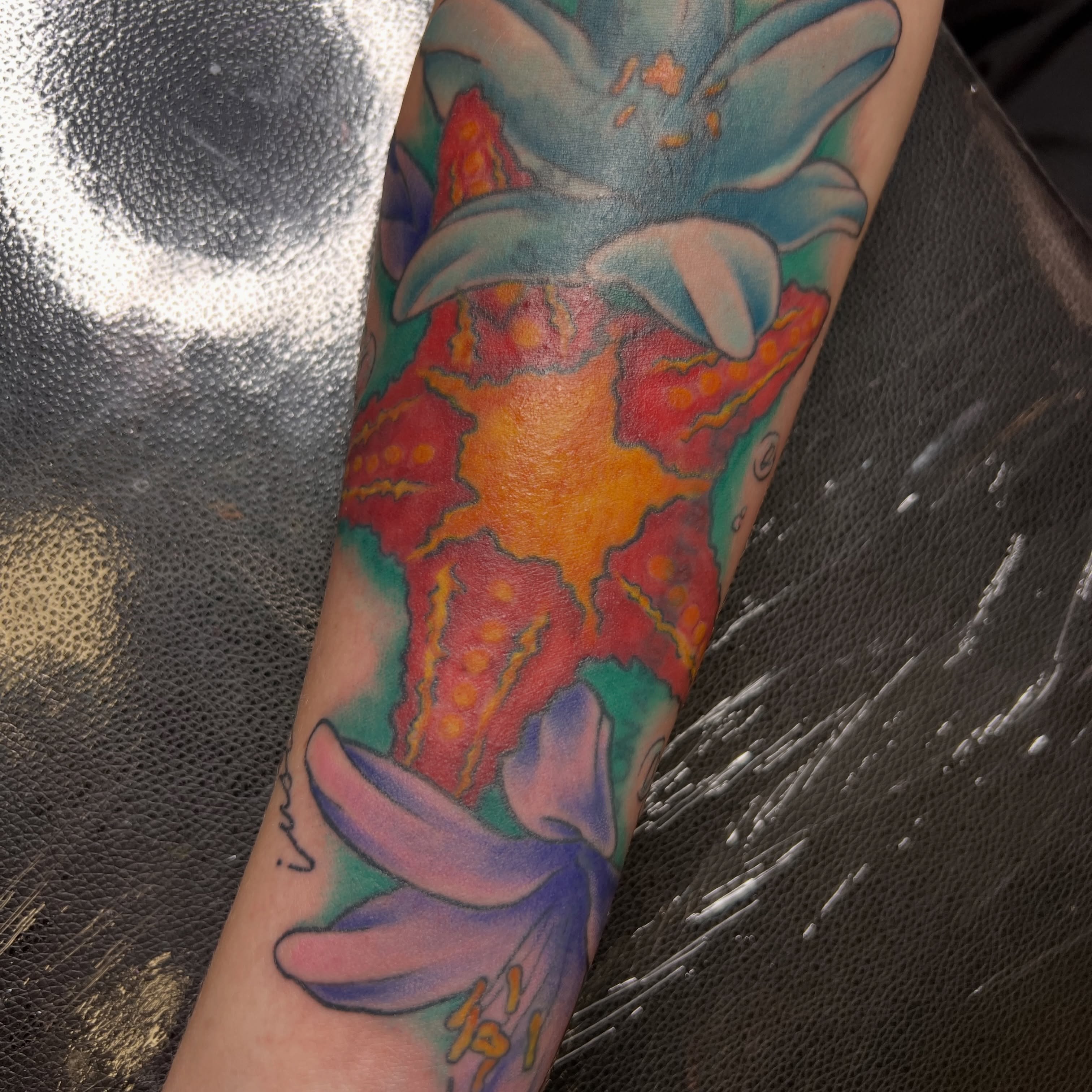 Lily and starfish new school tattoo on the forearm by Dani McBay
