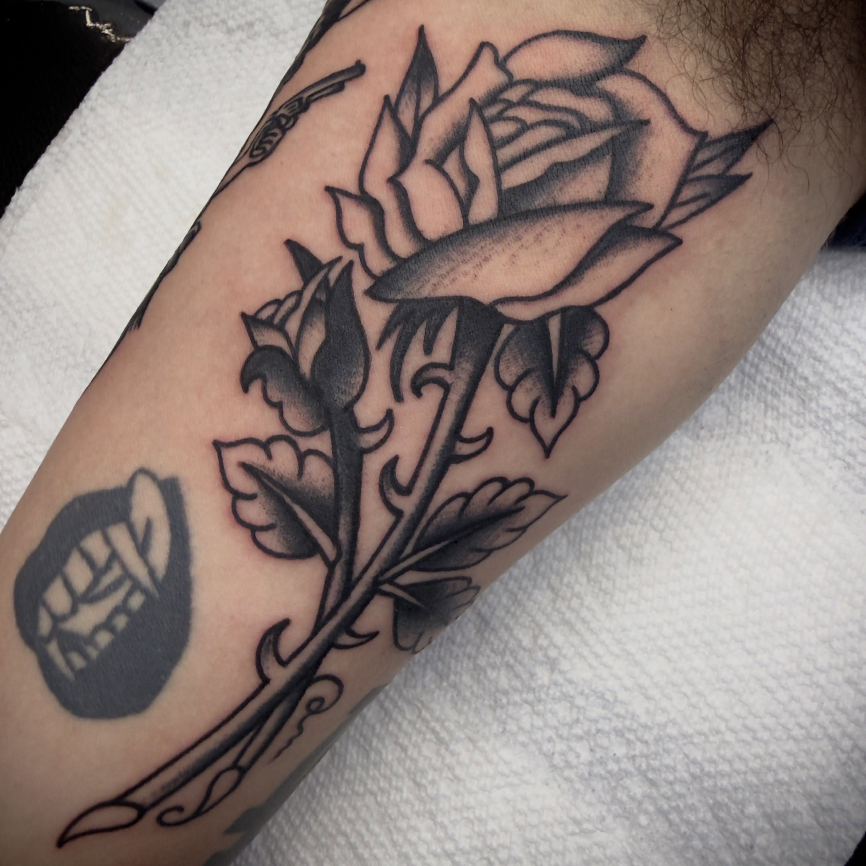 Rose and skull black and grey tattoo on the forearm by Andrew Slater
