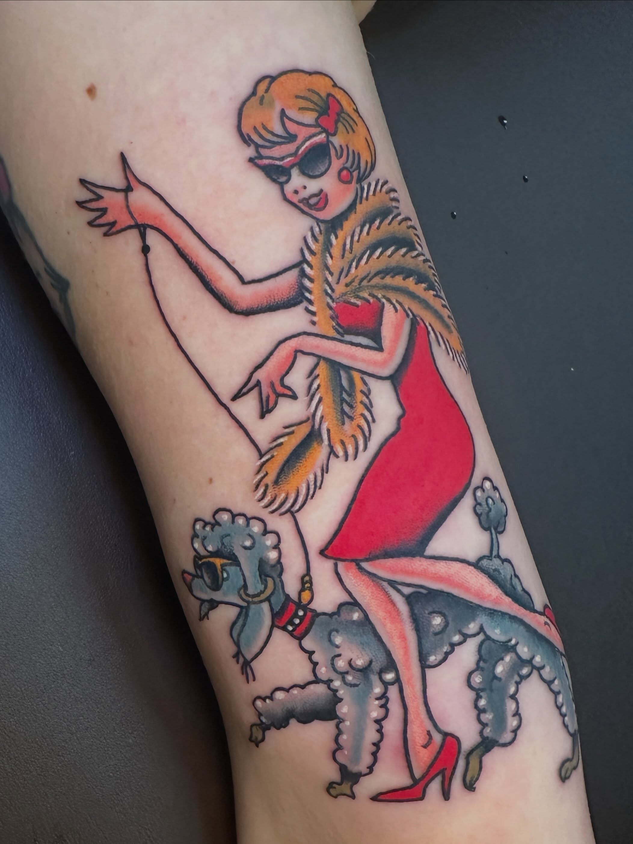Flapper girl riding poodle American traditional tattoo on the forearm by Stacey Colangelo