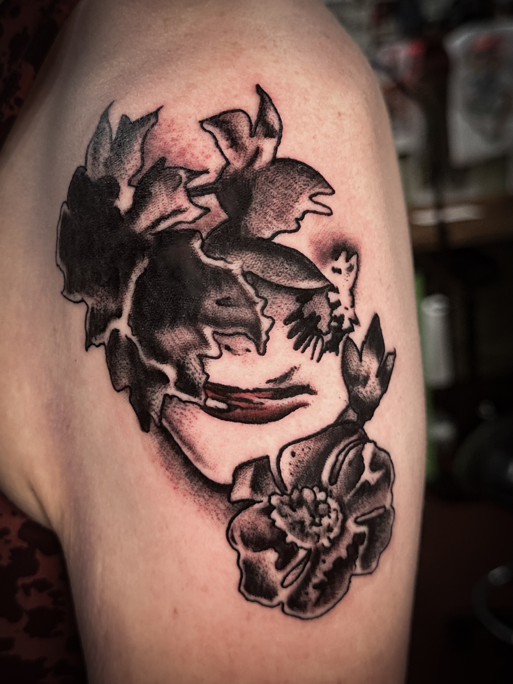 Joker face black and grey tattoo on the upper arm by Stacey Colangelo