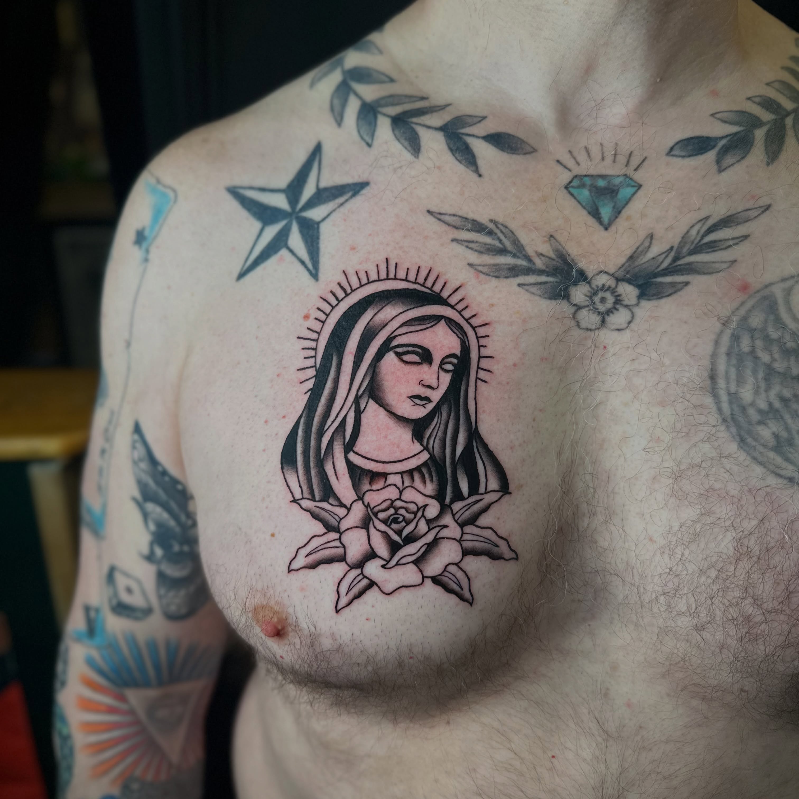Religious figure with rose American traditional tattoo on the chest by Tyyler Santor (Tattoo Artist), Somerville, Massachusetts